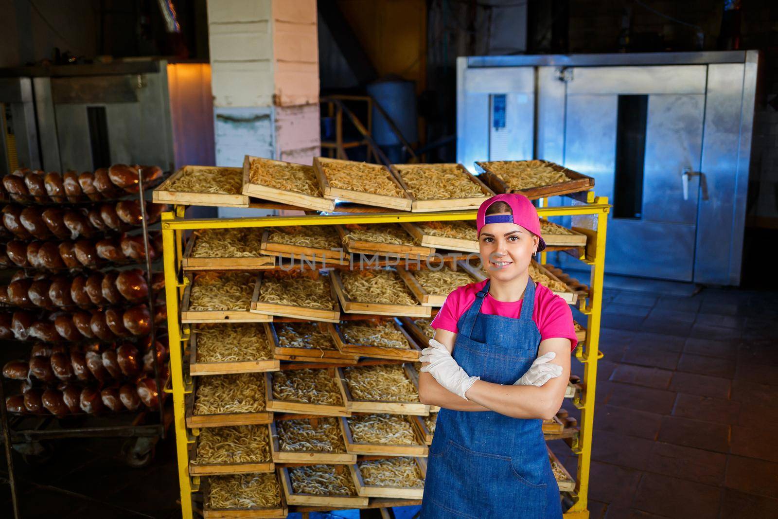 Worker with a box of pasta. The girl works on the production of spaghetti. Making noodles. Pasta factory.