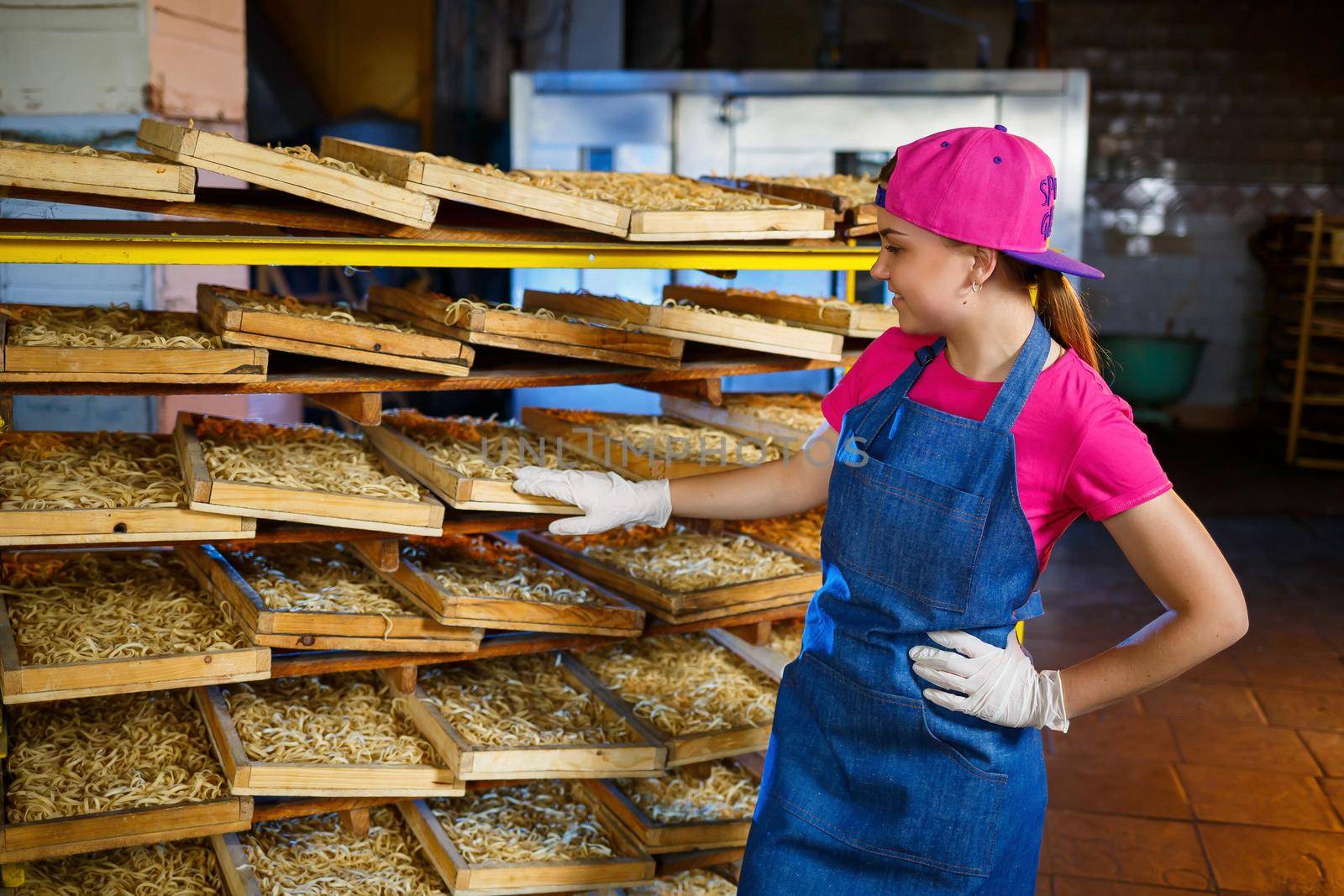 The girl is working on the production of spaghetti. Making noodles. Macaroni factory.