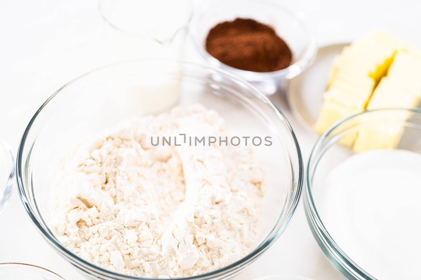Ingredients in glass bowls to bake chocolate bundt cake with chocolate frosting.