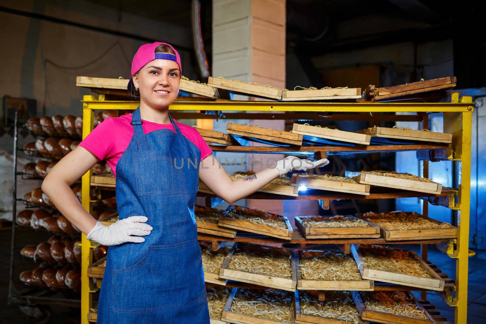 Worker with a box of pasta. The girl works on the production of spaghetti. Making noodles. Pasta factory.