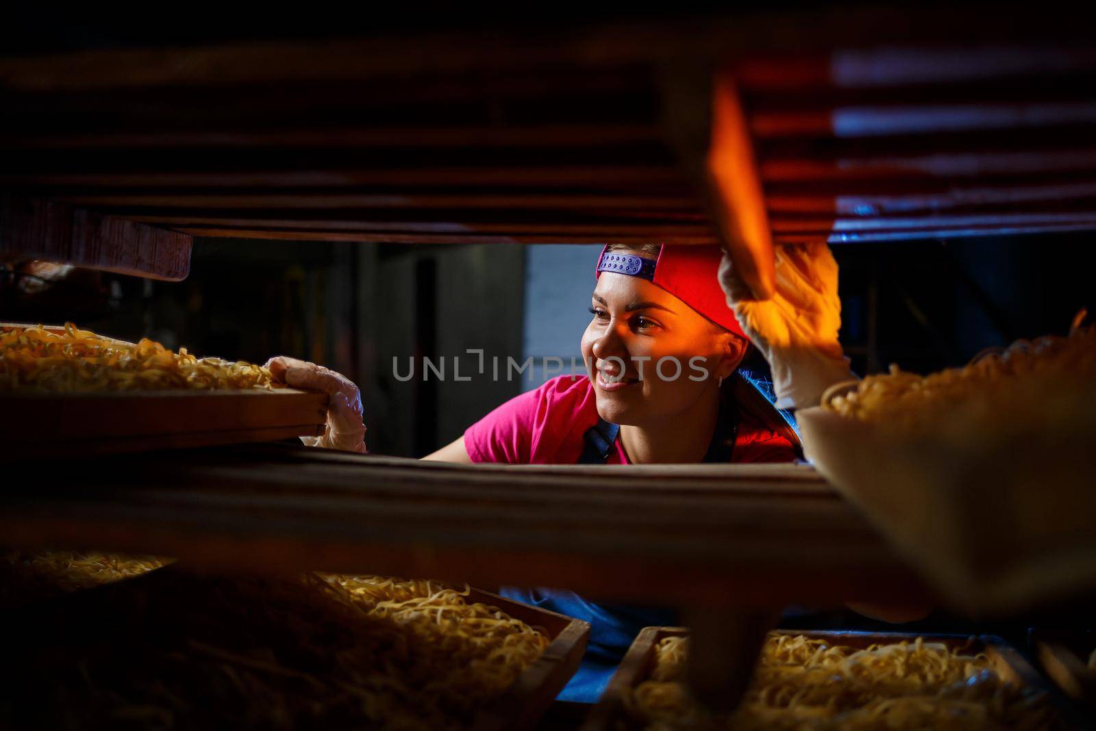 The girl is working on the production of spaghetti. Making noodles. Macaroni factory.