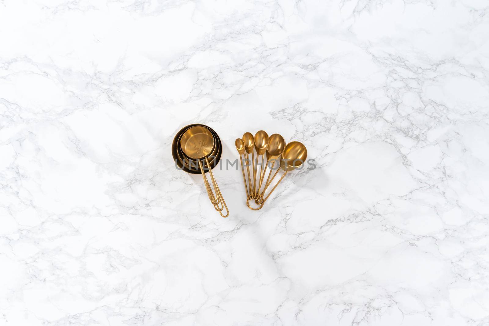 Flat lay. Cupper measuring cups and spoons for baking on a marble countertop.