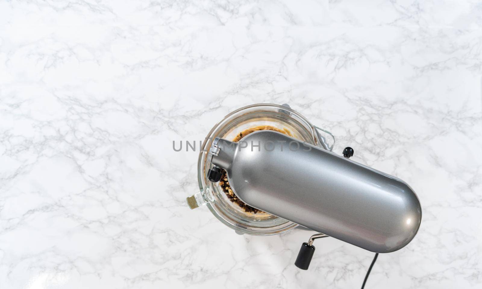 Flat lay. Mixing ingredients in a kitchen stand mixer to bake soft oatmeal raisin walnut cookies.