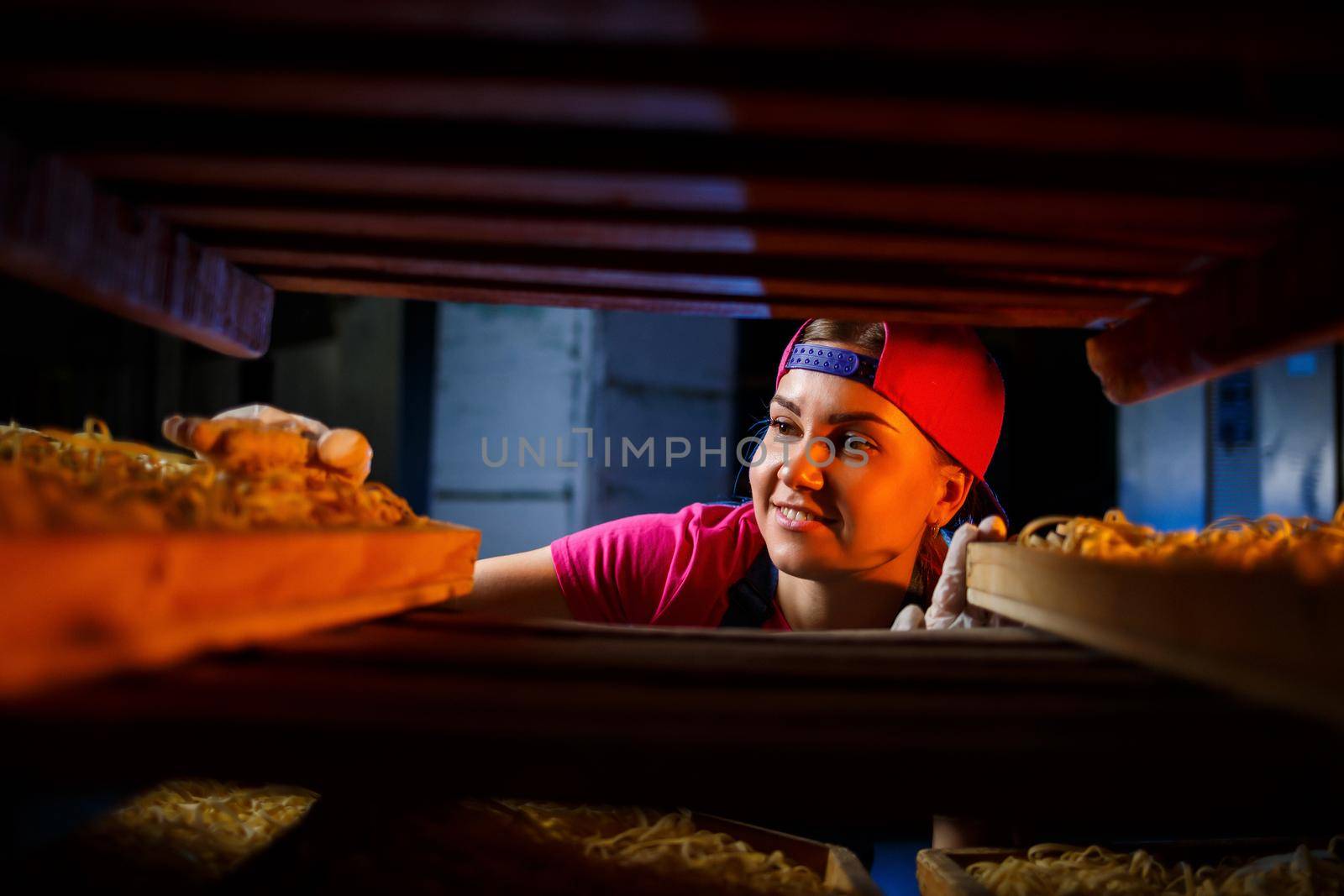 The girl works on the production of spaghetti. Making noodles. Pasta factory.