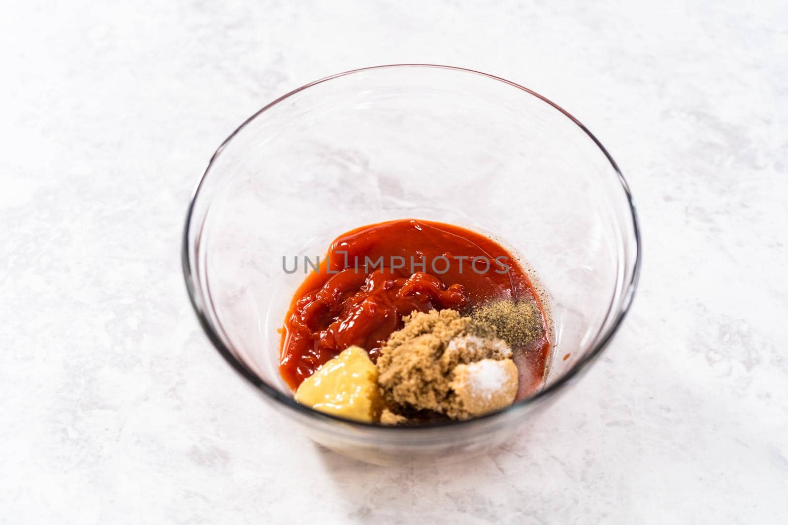 Mixing ingredients with a hand whisk to make a sweet glaze for meatloaf.