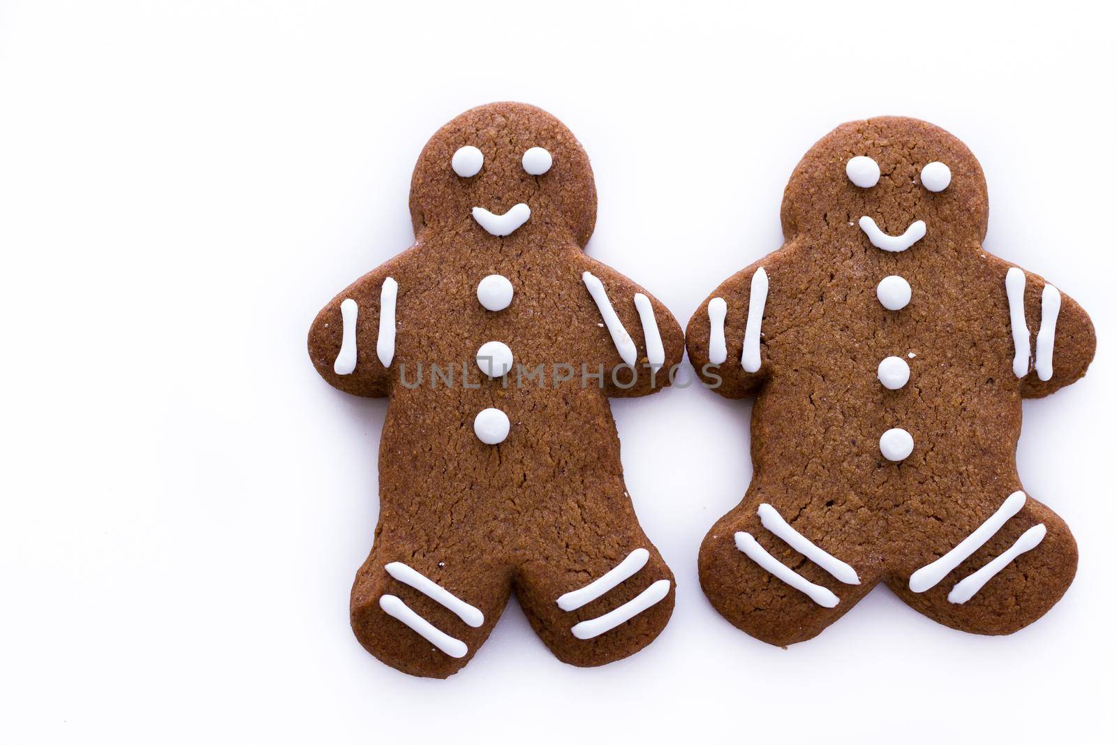 Homemade gingerbread cookies decorated with white icing on white background.