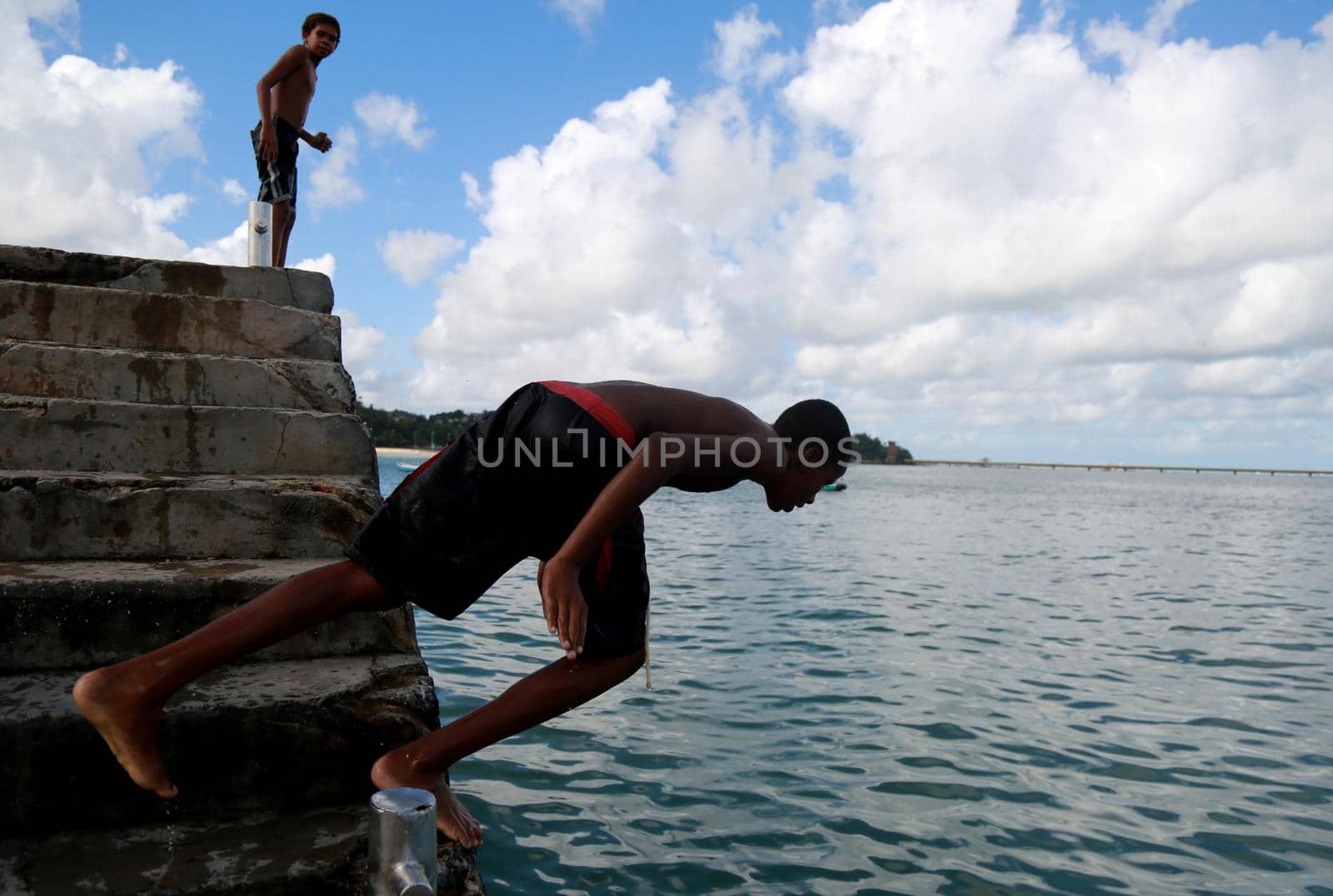 salvador, bahia / brazil - june 5, 2015: Young people are seen jumping from the boats pier in Sao Tome de Paripe, suburb of Salvador.




 