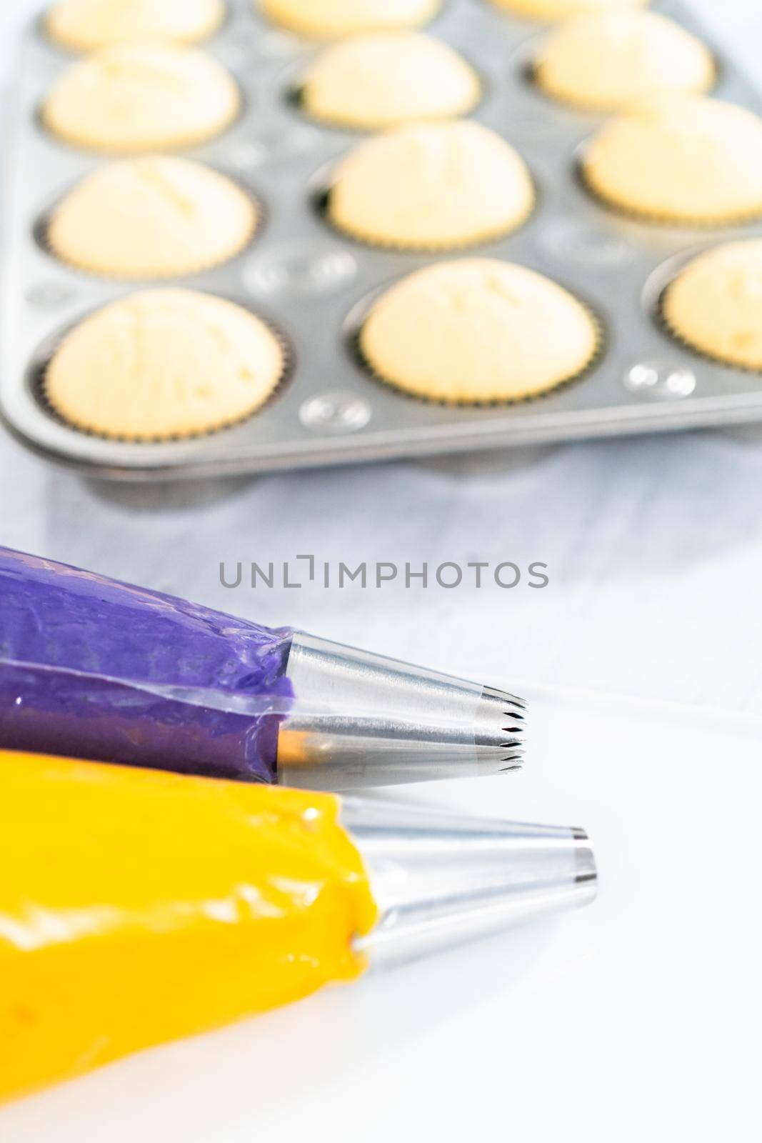 Italian buttercream batter in a piping bag with metal jumbo cupcake tips.