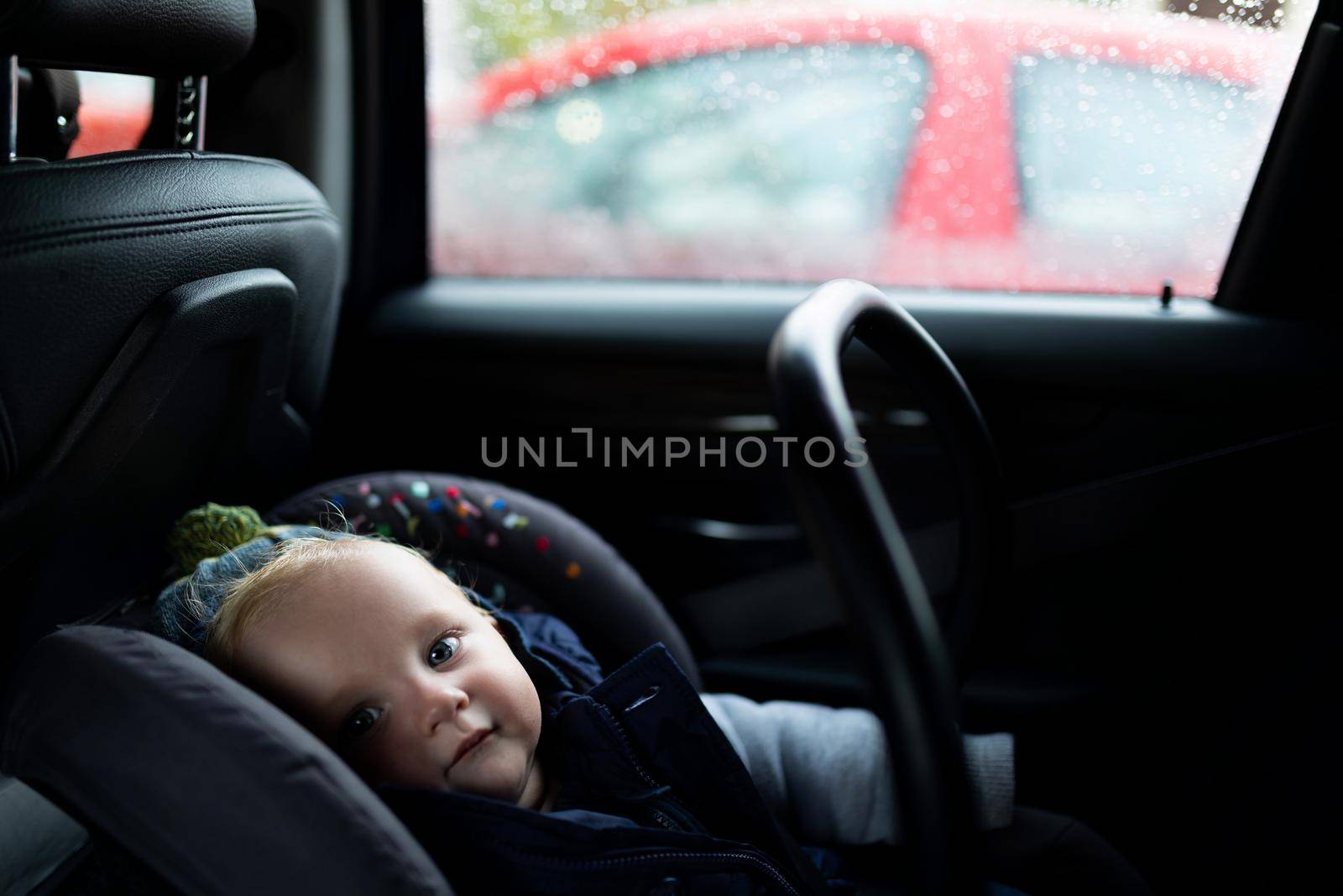 baby sitting in a car in a carrier, photo with depth of field. Child safety concept by TRMK