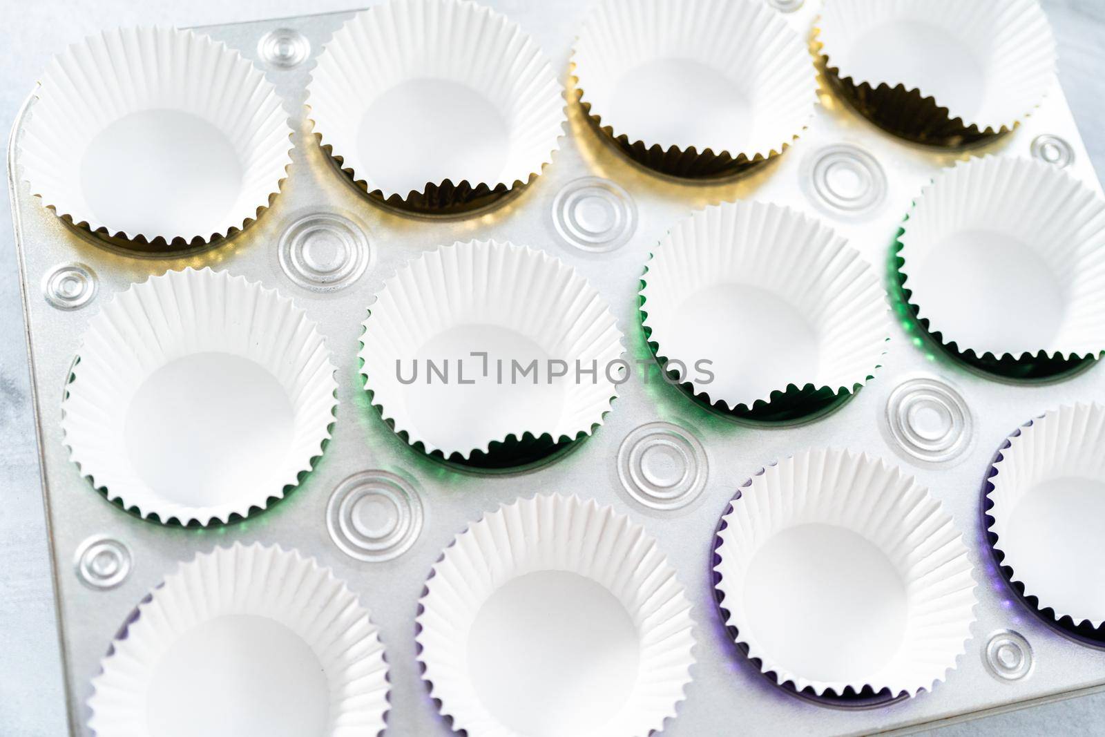 Colorful foil baking cupcake liners in cupcake pan.