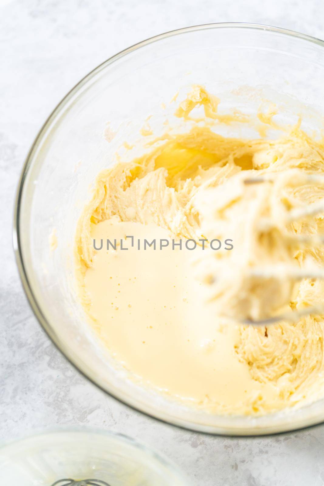 Mixing ingredients in a glass mixing bowl to bake July 4th bundt cake with chocolate stars.