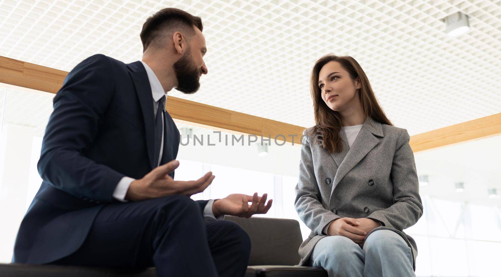 communication company employees colleagues men and women sitting on the couch, the concept of interaction between a client and a lawyer by TRMK