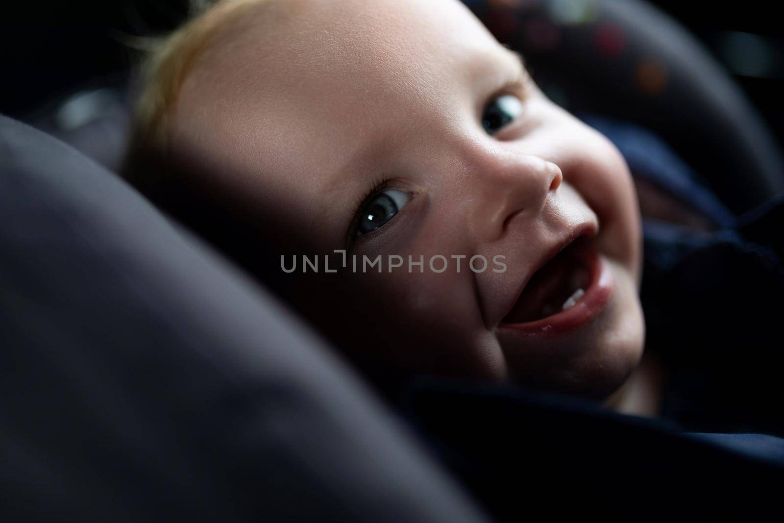 smiling baby in a carrier, traffic safety concept.