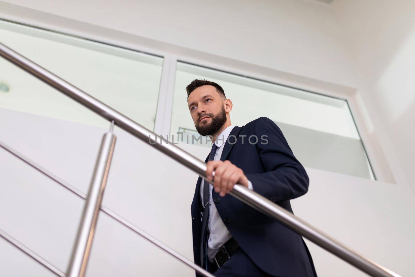 businessman in a business suit climbs the stairs to the top. Career growth concept