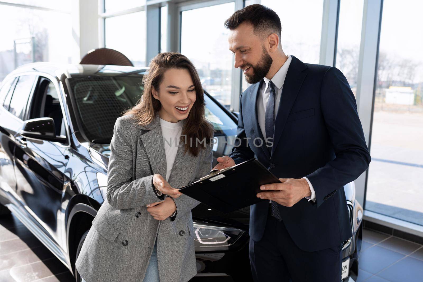 an employee of an insurance company helps to understand the insurance policy of a buyer of a new car.