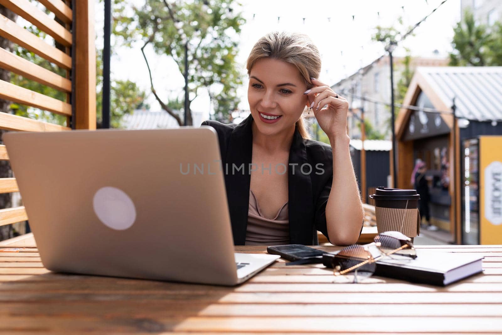 young business woman working on laptop outdoors.