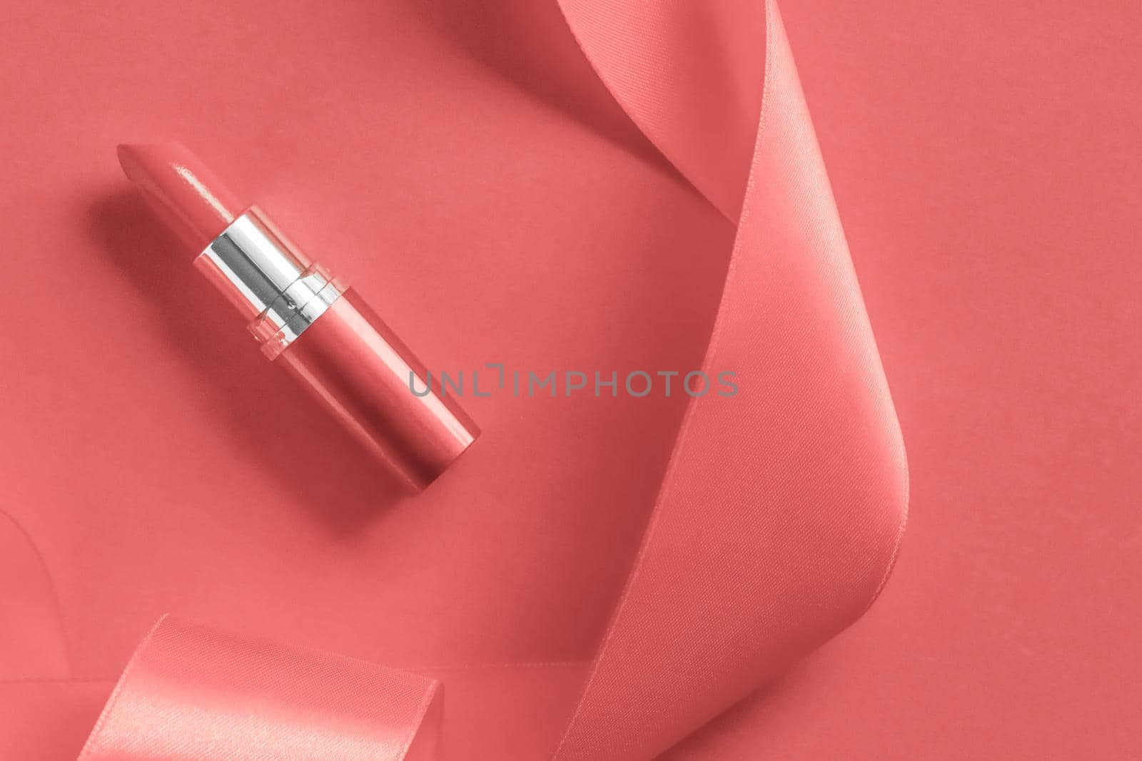 Cosmetic branding, glamour lip gloss and shopping sale concept - Luxury lipstick and silk ribbon on coral holiday background, make-up and cosmetics flatlay for beauty brand product design