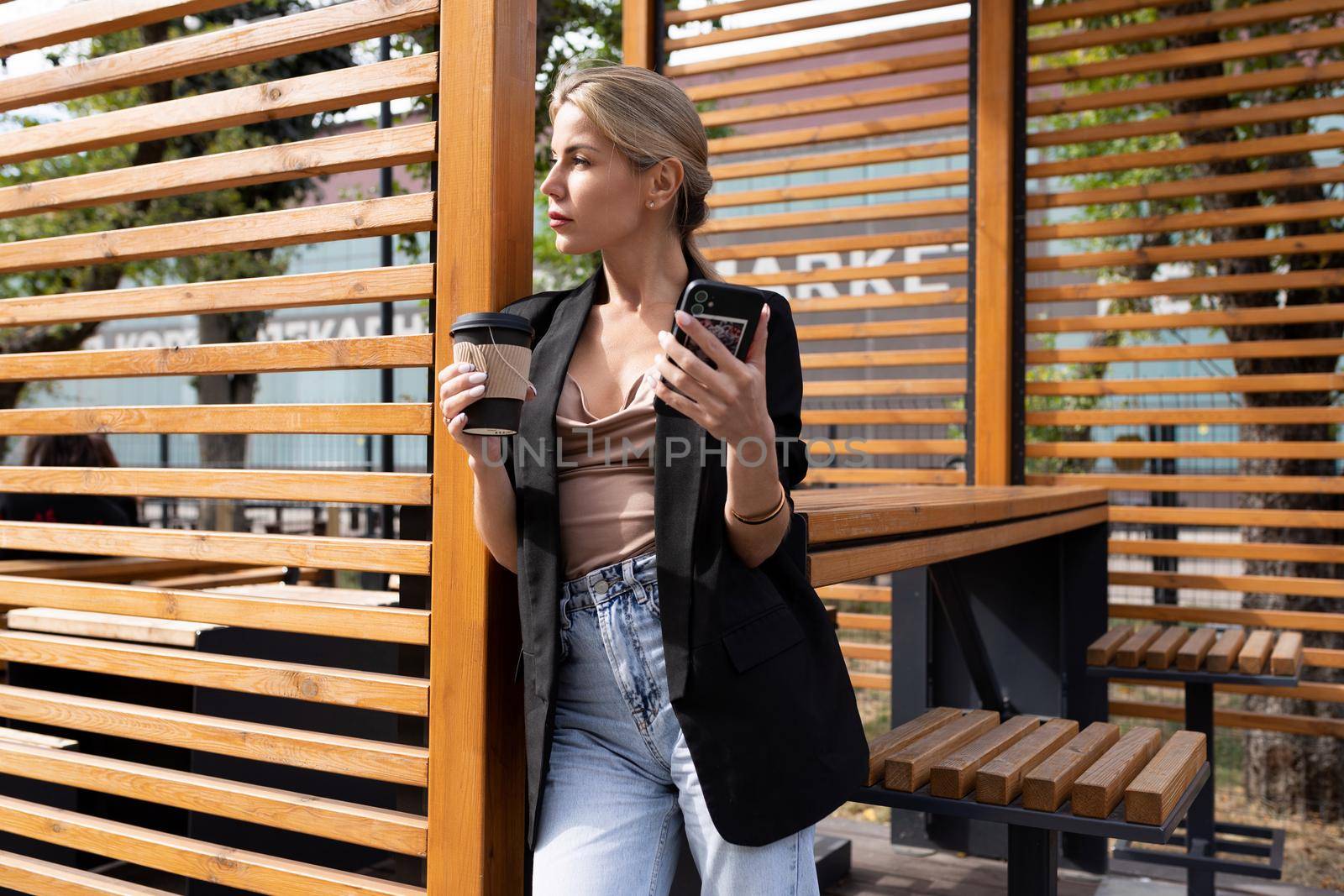 young successful woman during a break in a cafe with a mobile phone and coffee.