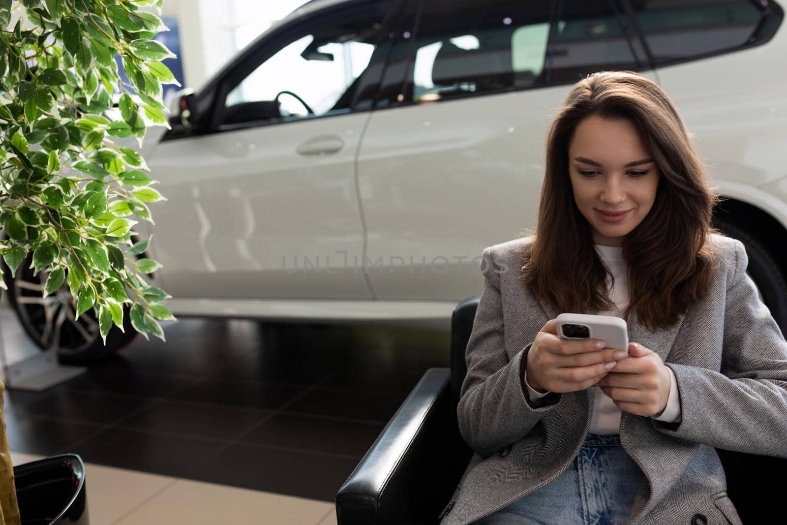young woman in a car dealership waiting for the manager at the reception by TRMK