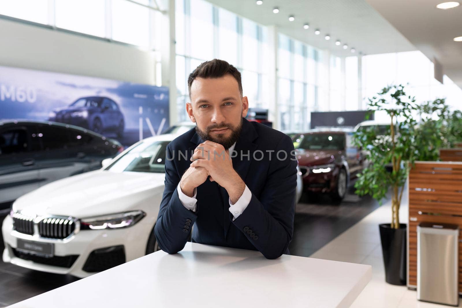 male businessman on the background of new cars in the dealership.