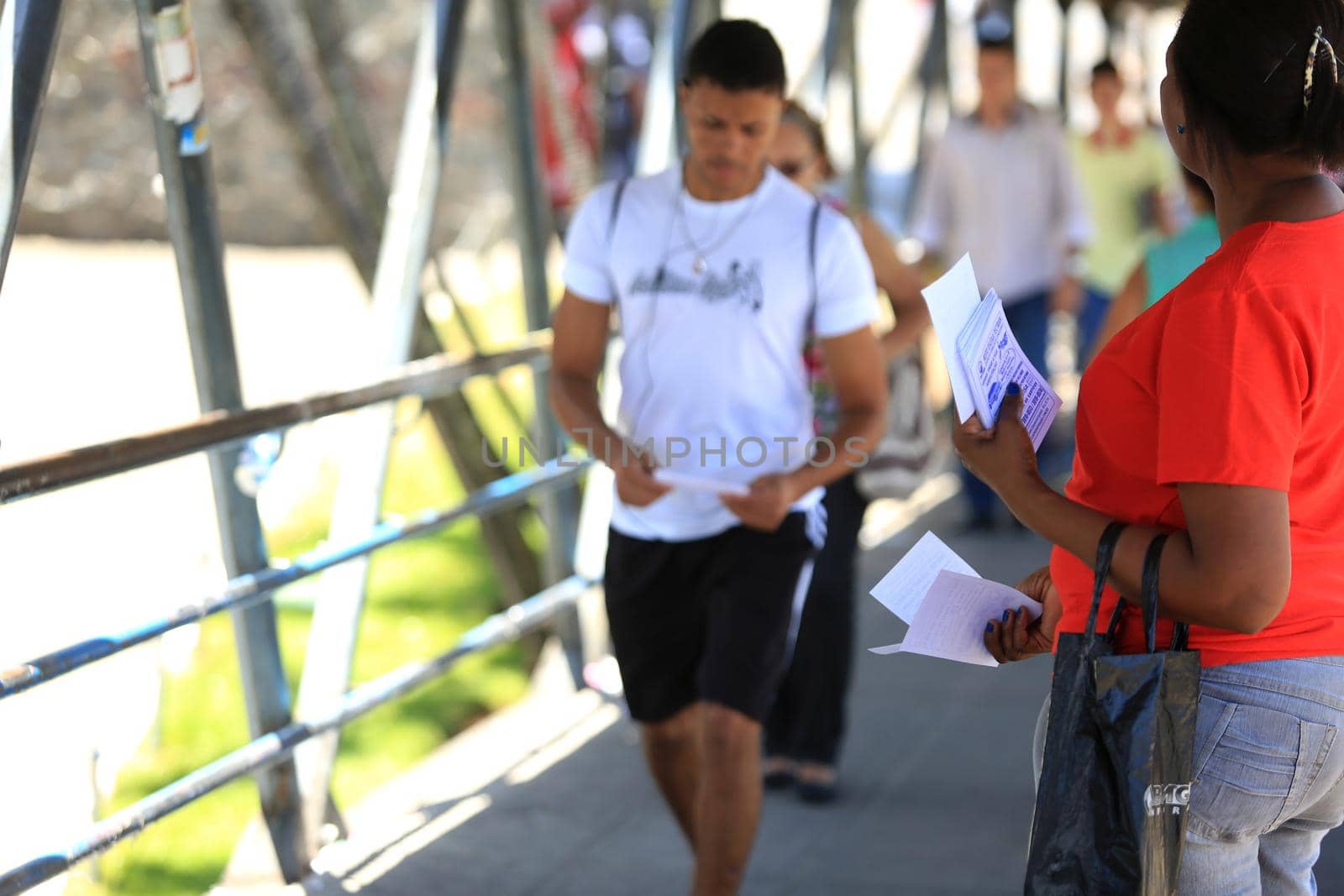 salvador, bahia, brazil - november 12, 2015: Young man is seen handing out advertising leaflets in front of a pedestrian crossing in the city of Salvador.