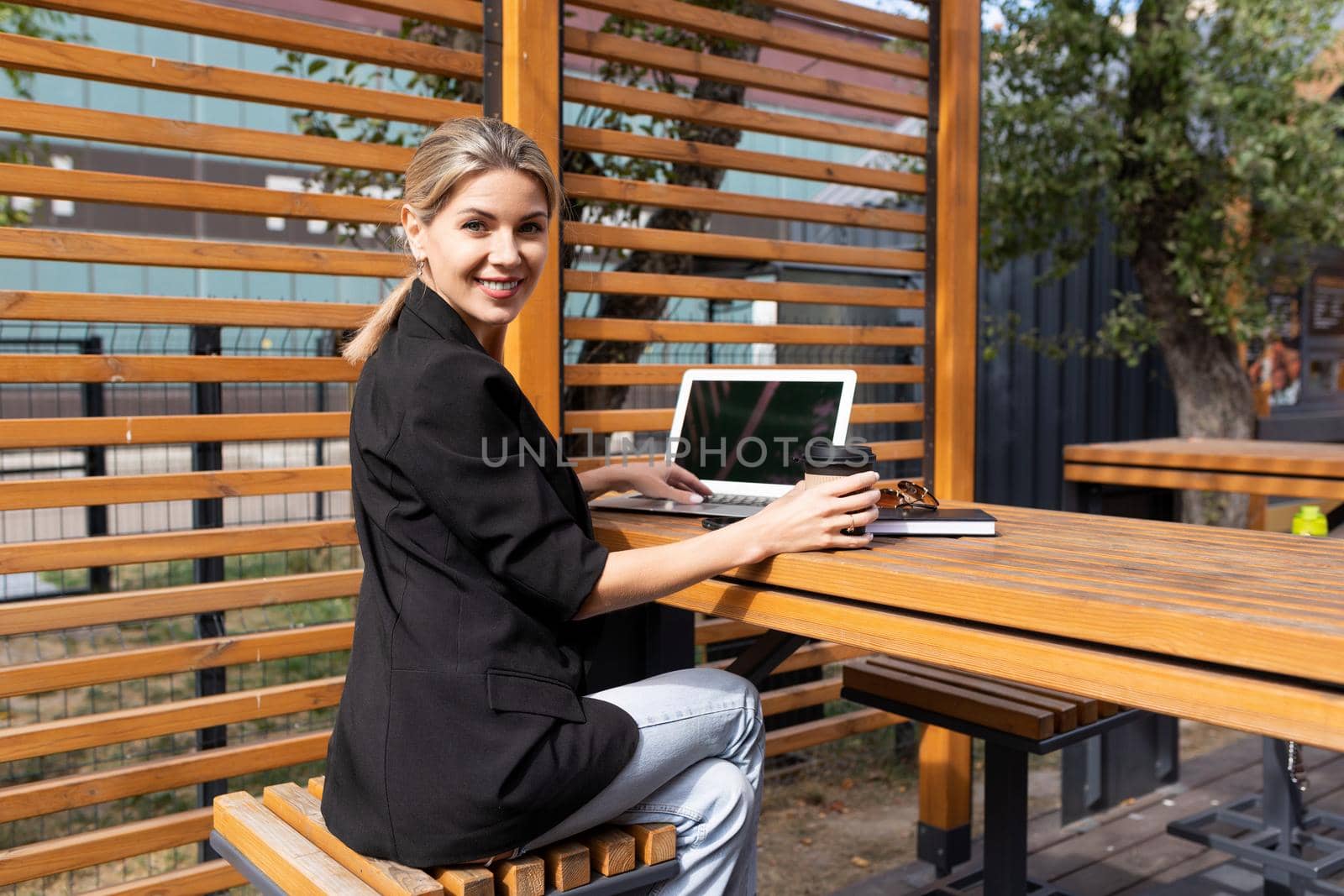Business young woman with a laptop at a table in a cafe.