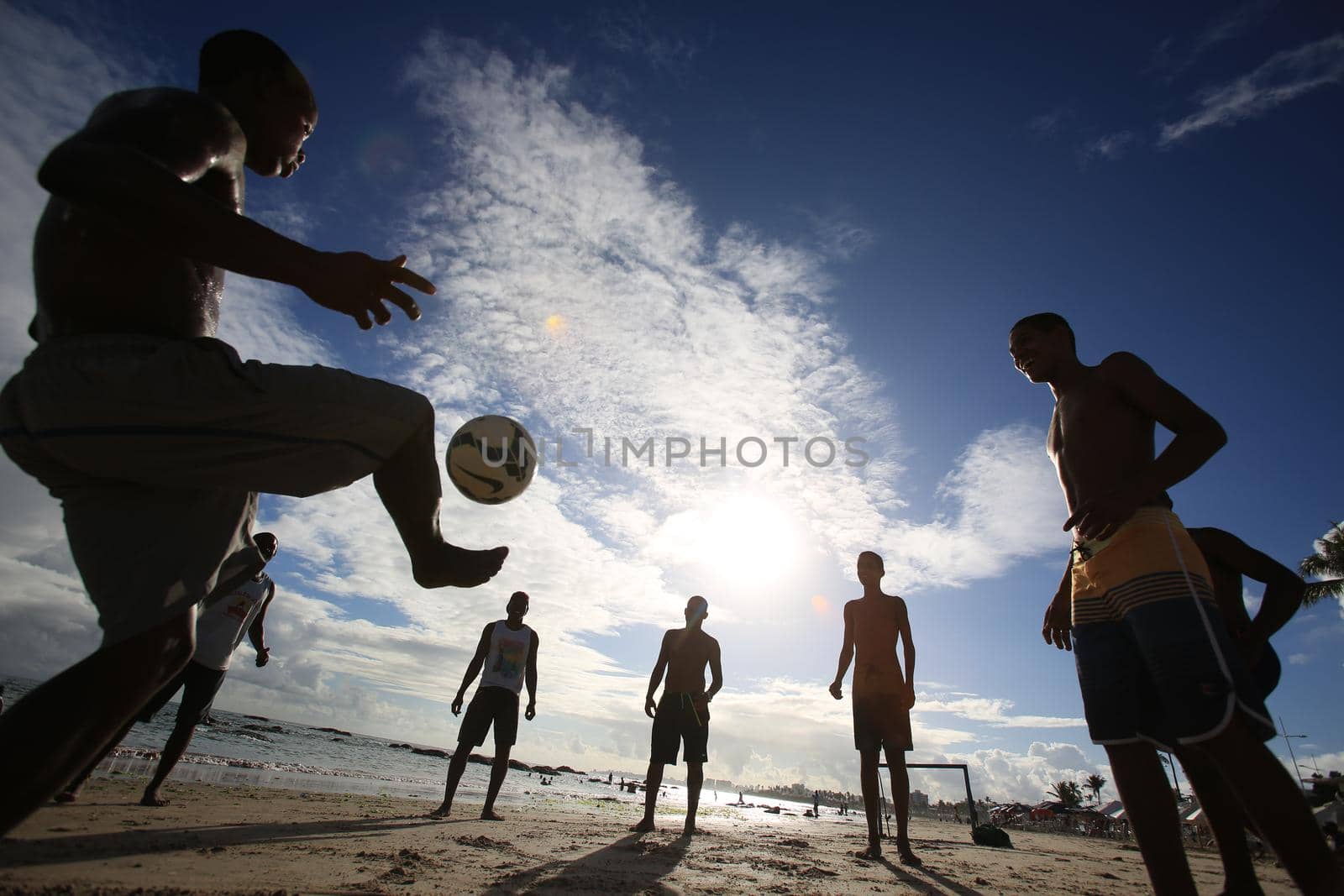 salvador, bahia / brazil - december 22, 2015: Young people are seen playing soccer at Itapua Beach in Salvador.