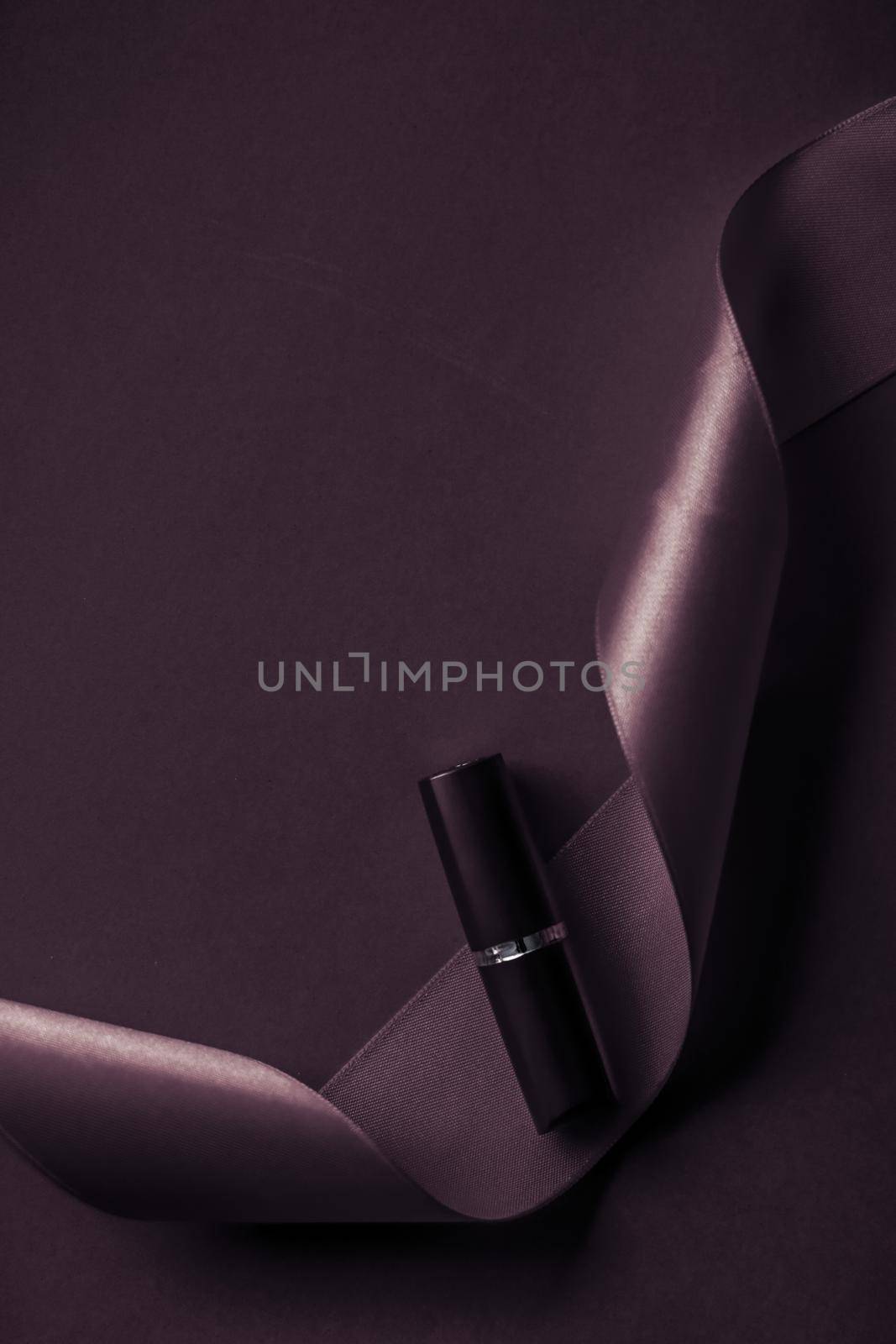 Cosmetic branding, glamour lip gloss and shopping sale concept - Luxury lipstick and silk ribbon on dark purple holiday background, make-up and cosmetics flatlay for beauty brand product design