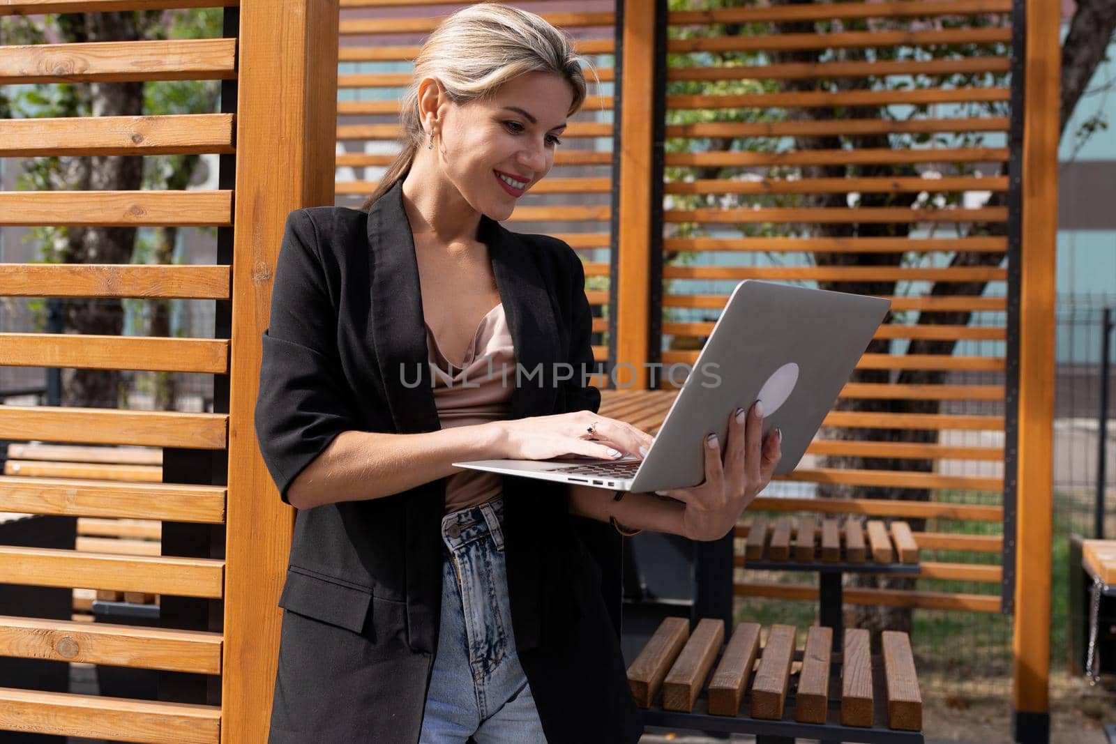 stylish young businesswoman with laptop outdoors.