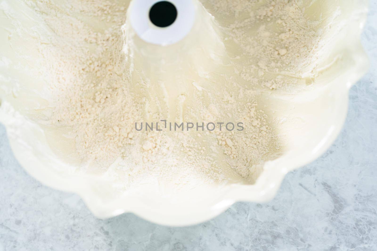Close up view. Greasing bundt cake pan with vegetable shortening and flour to bake funfettti bundt cake.