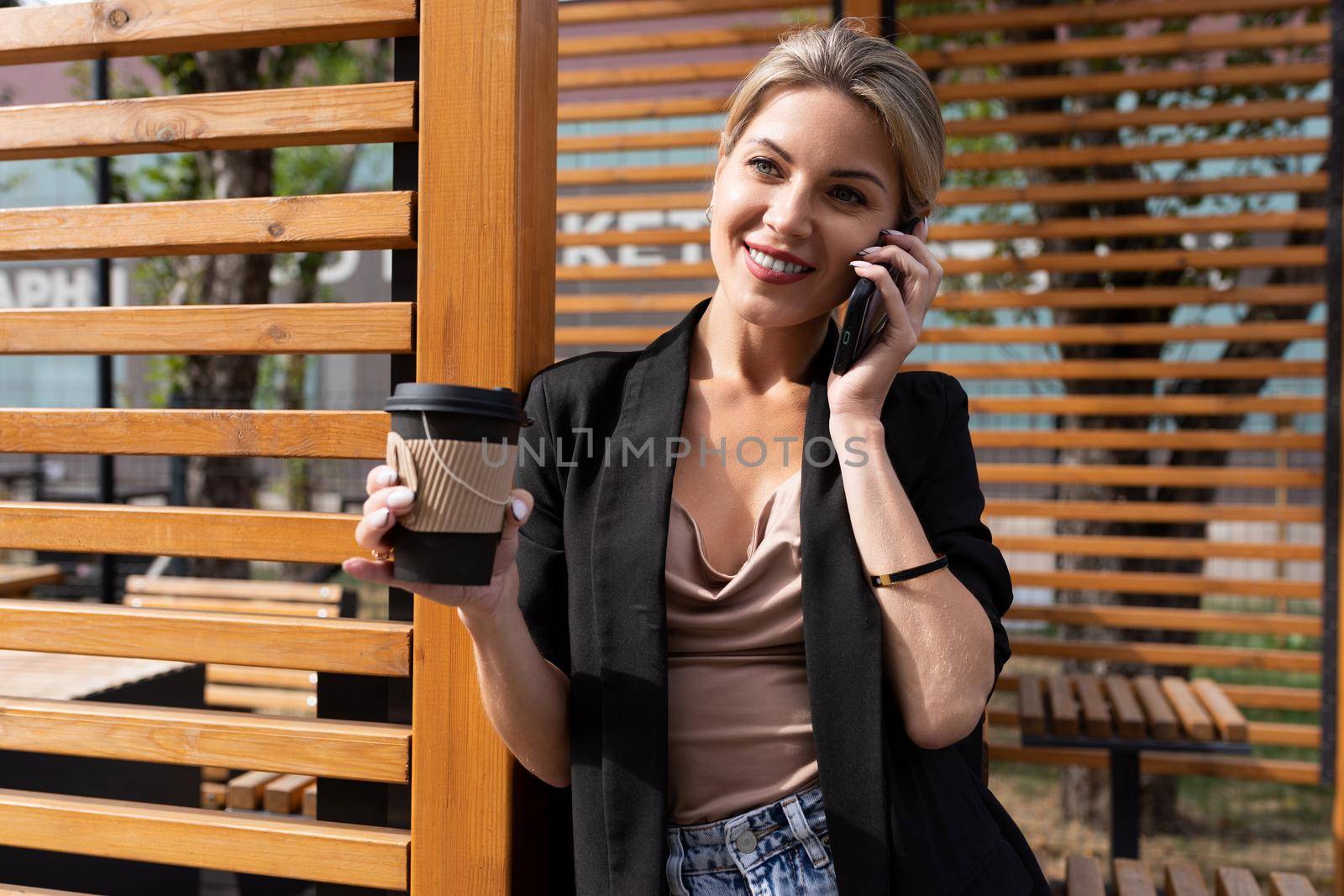 successful middle-aged woman talking on the phone during a lunch break in a cafe.