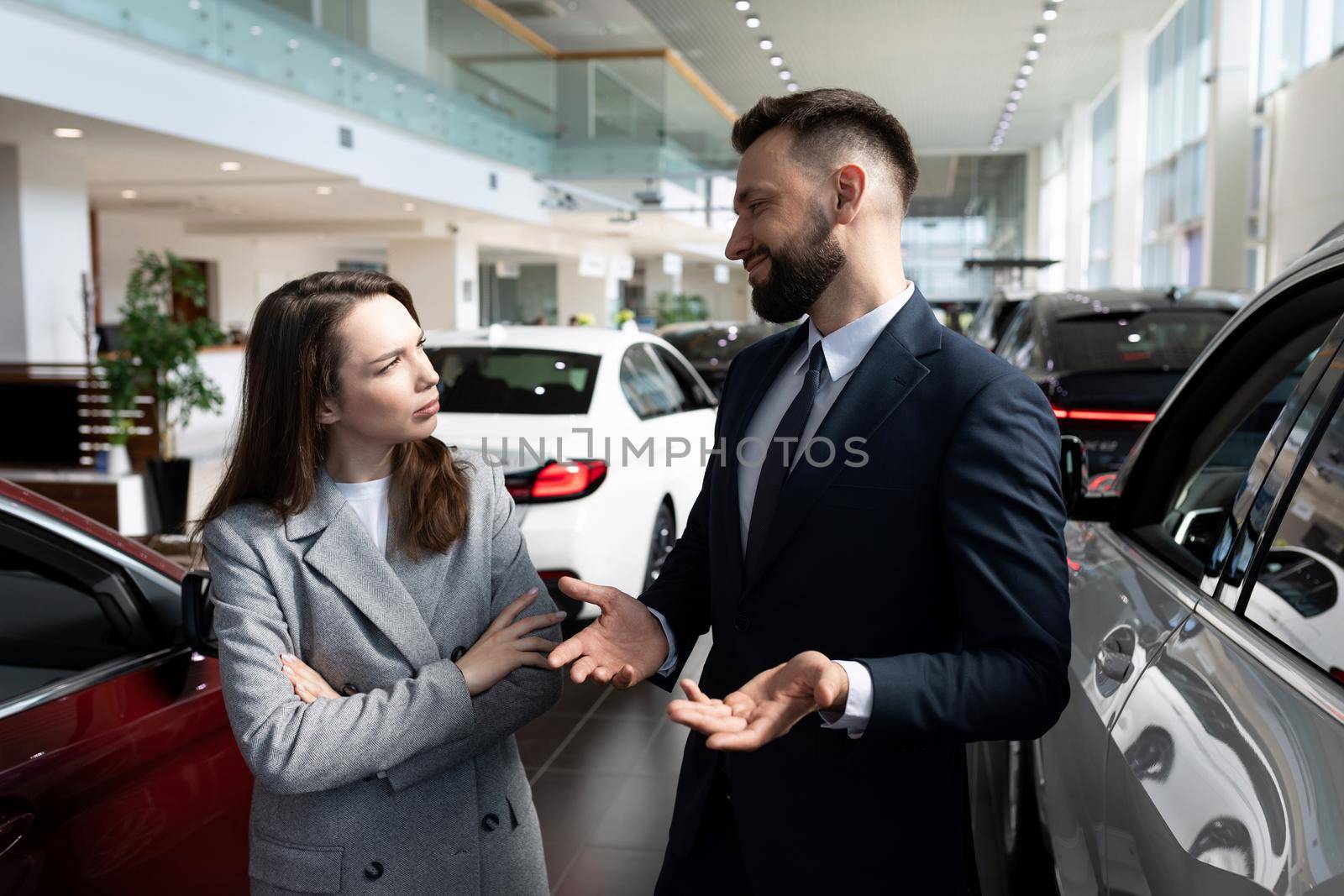 a young woman negotiates a long-term car rental at a car dealership, concept after car warranty service by TRMK