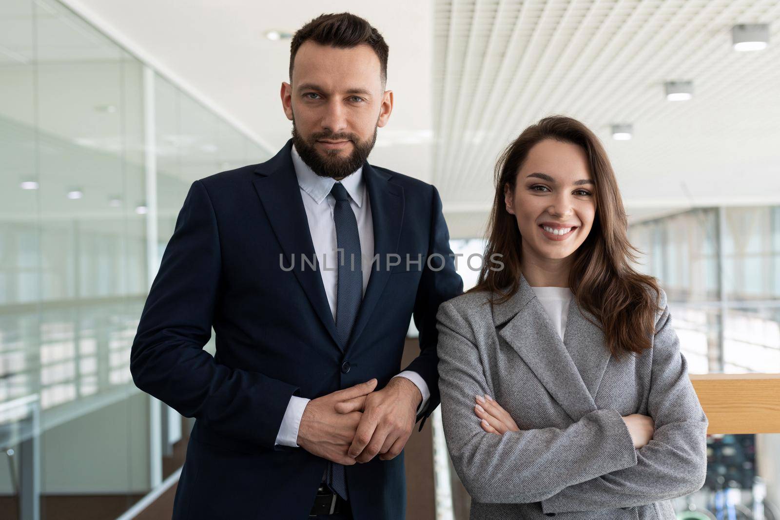heterosexual company executives in business suits against the backdrop of a modern stylish office.