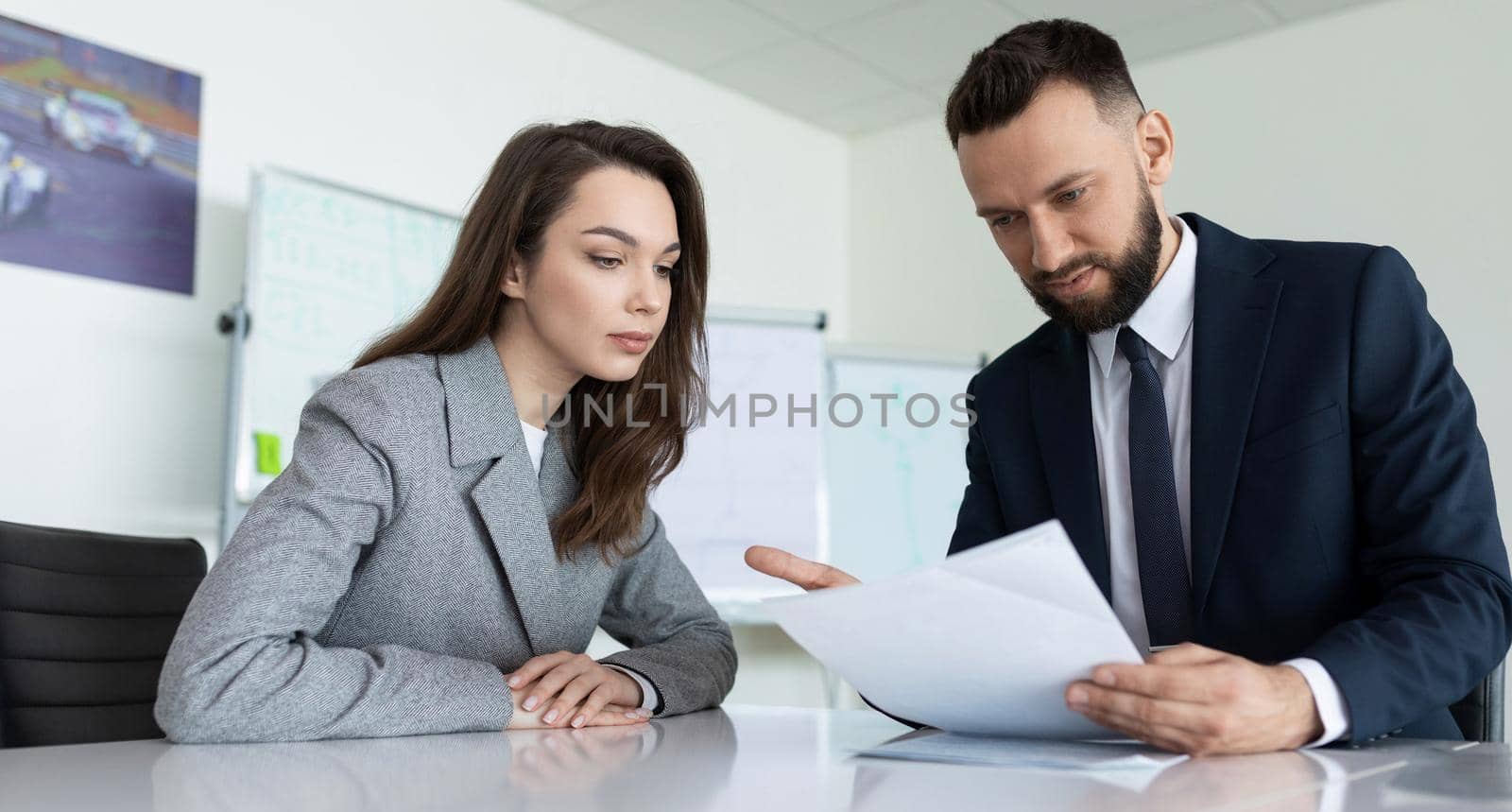 manager reads a report to his subordinate in the office.