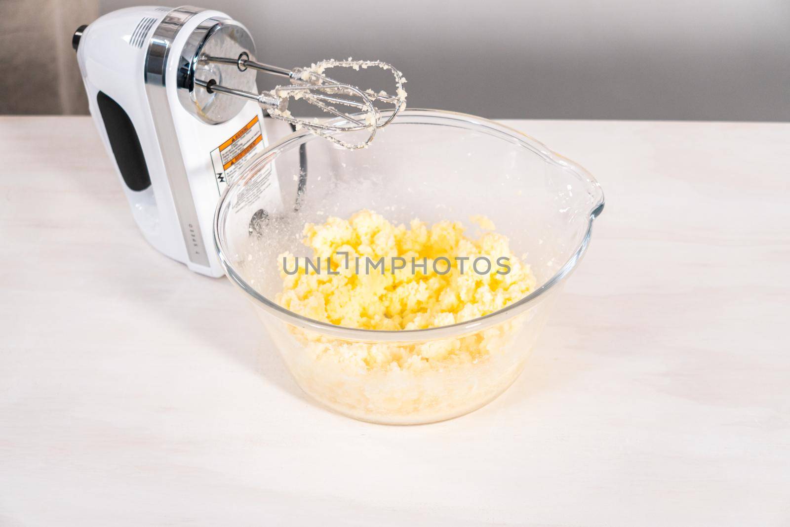 Mixing ingredients in a glass mixing bowl to bake chocolate bundt cake with chocolate frosting.