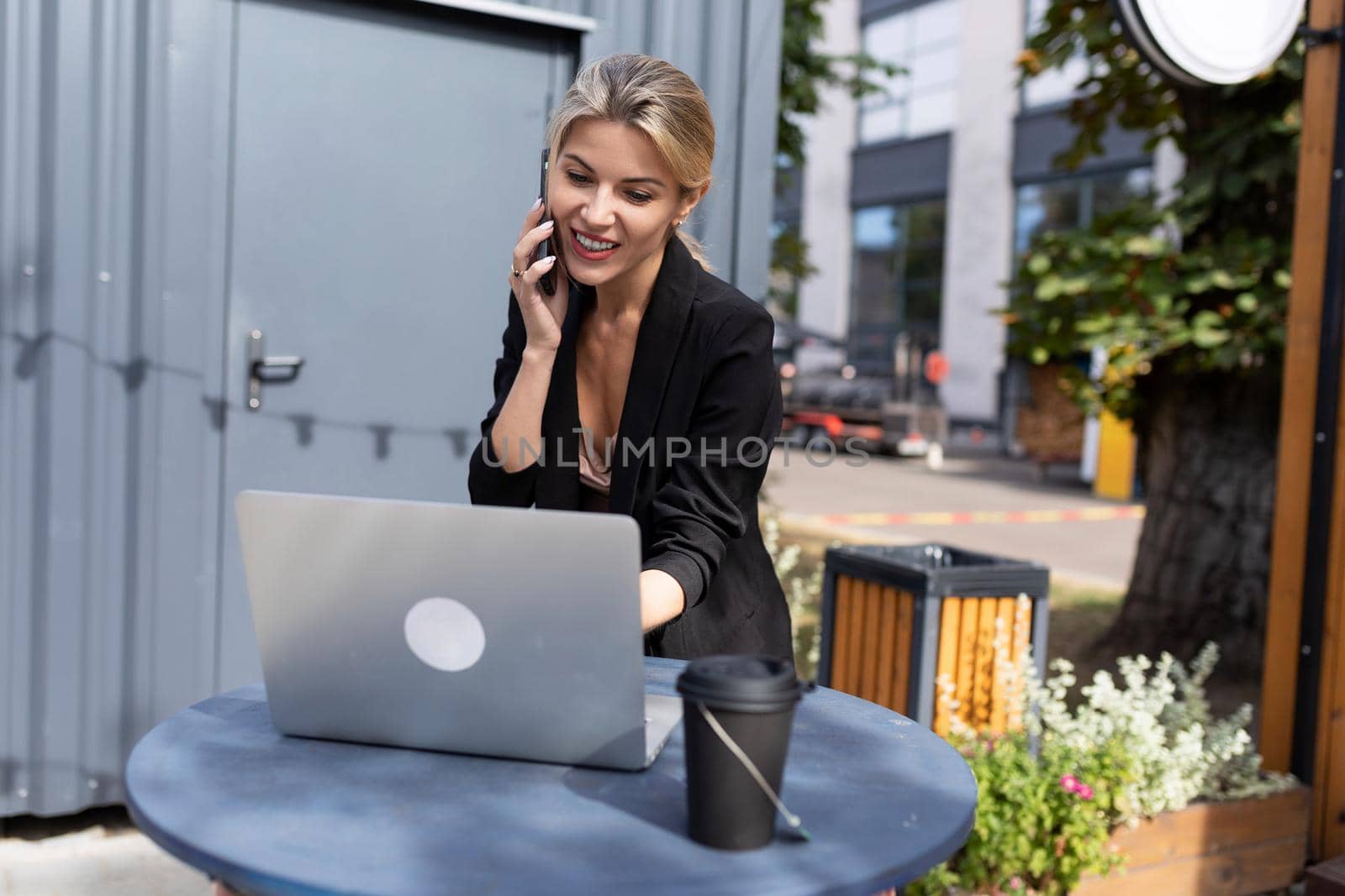 young successful woman working on a laptop in the street.