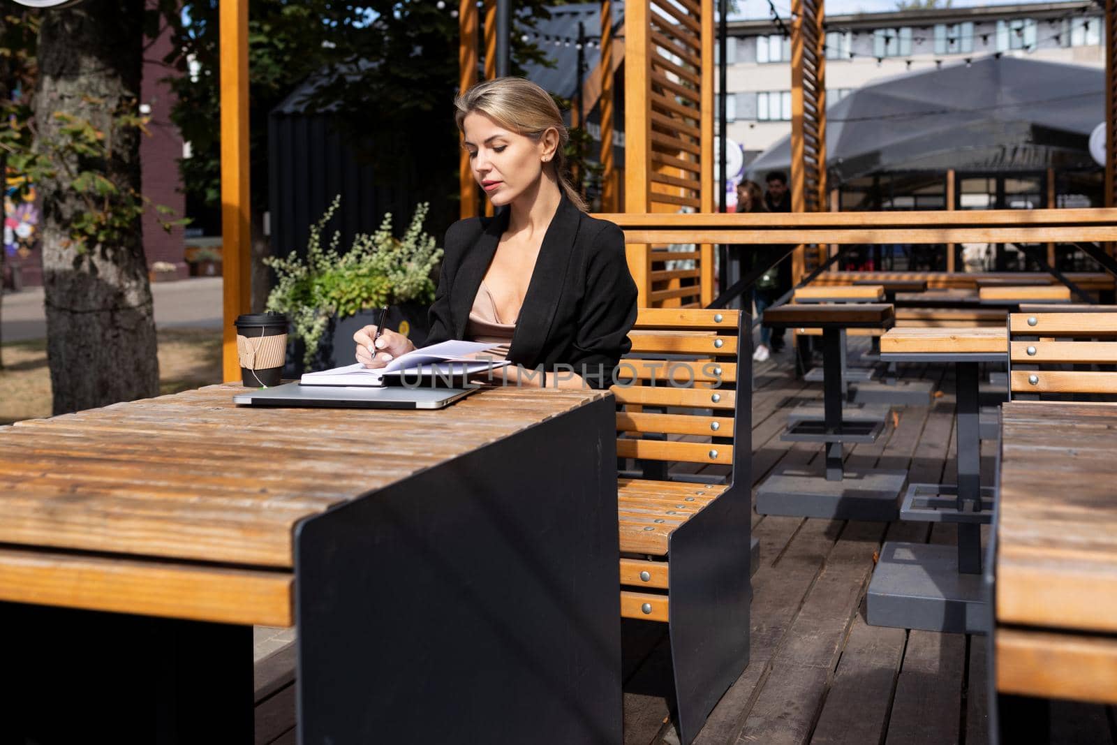 young business woman sitting in a cafe with a laptop diary.