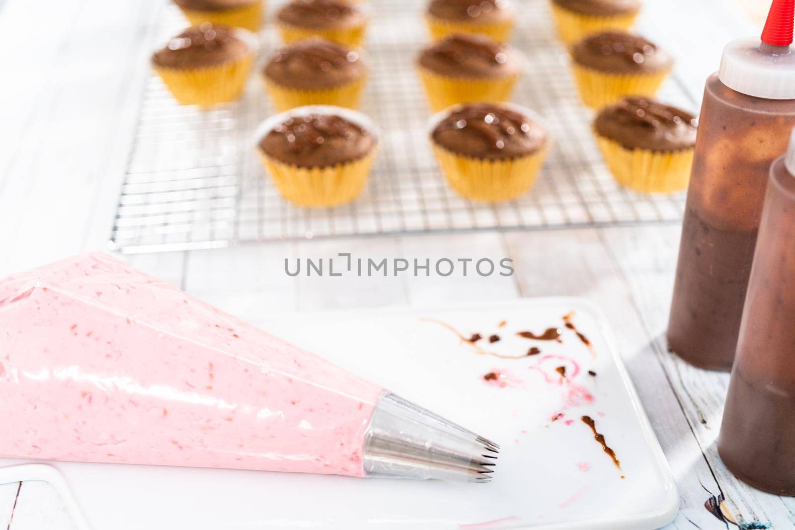 Raspberry cream cheese frosting in a piping bag with metal tip.