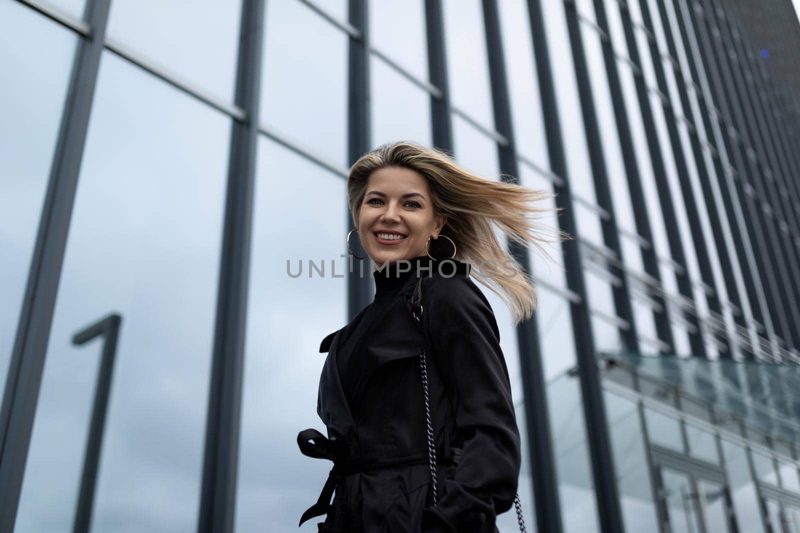 woman Businesswoman with flying hair in the wind against the backdrop of an office building.