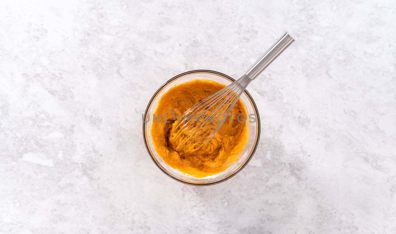 Flat lay. Mixing ingredients in a glass mixing bowl to bake sweet pumpkin bread.