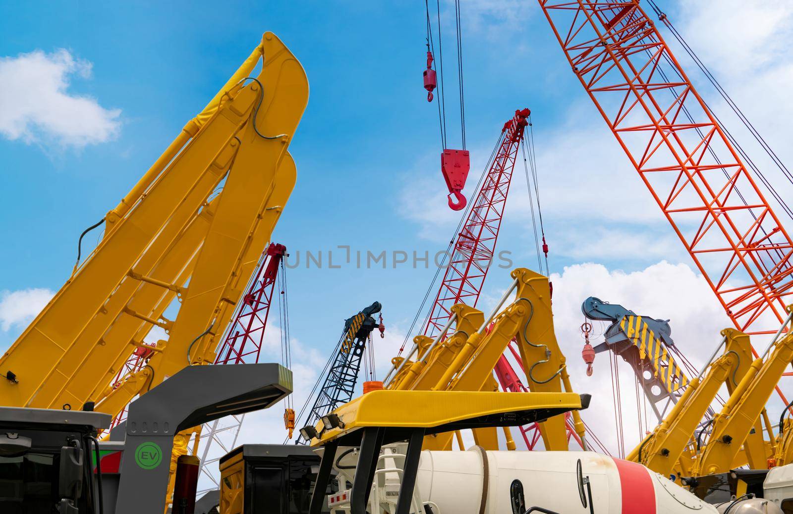 Crawler crane against blue sky. Real estate industry. Red crawler crane use reel lift up equipment in construction site. Crane for rent at parking lot. Crane dealership for construction business. by Fahroni