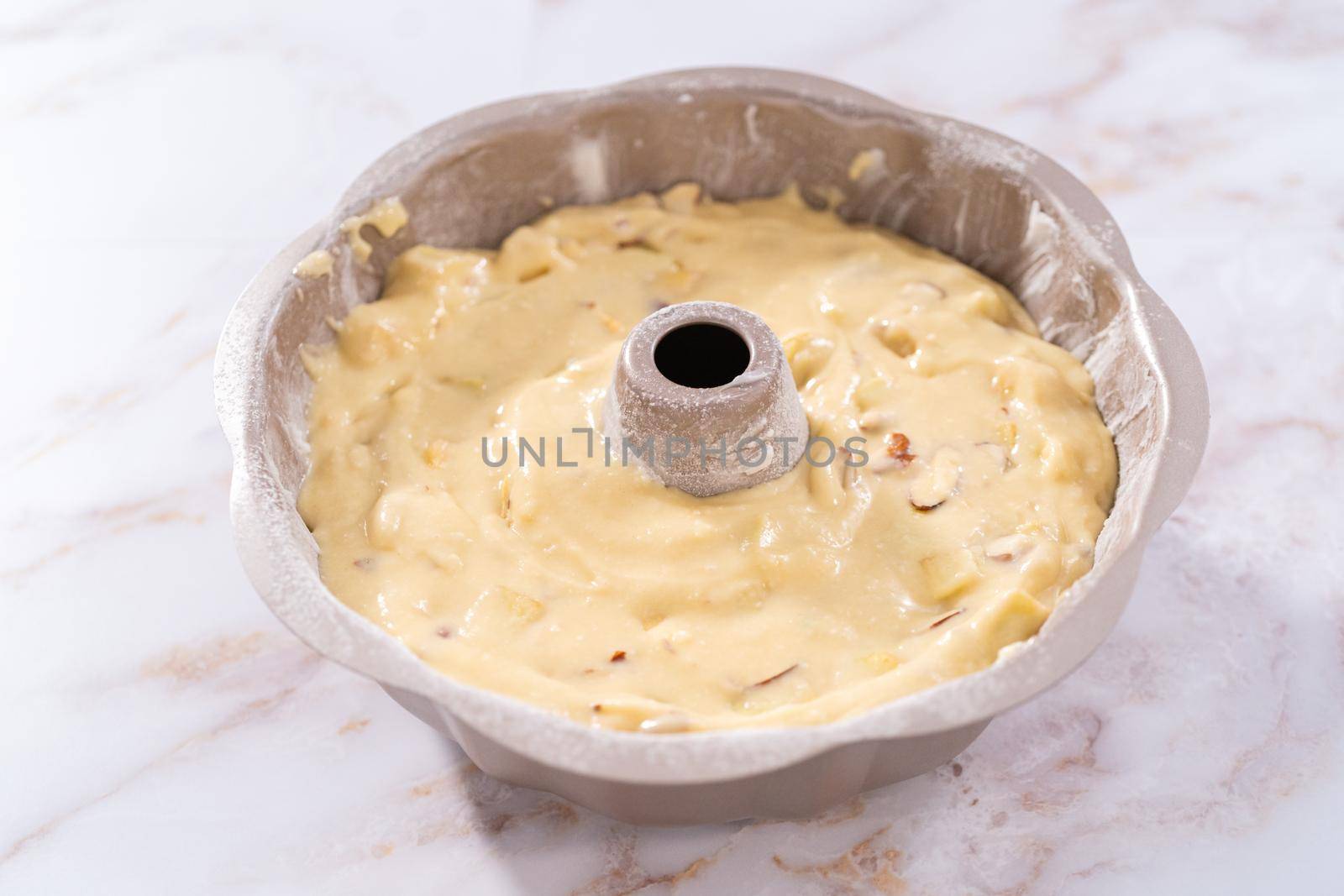 Cake batter in a bundt cake pan to bake apple bundt cake with caramel glaze.