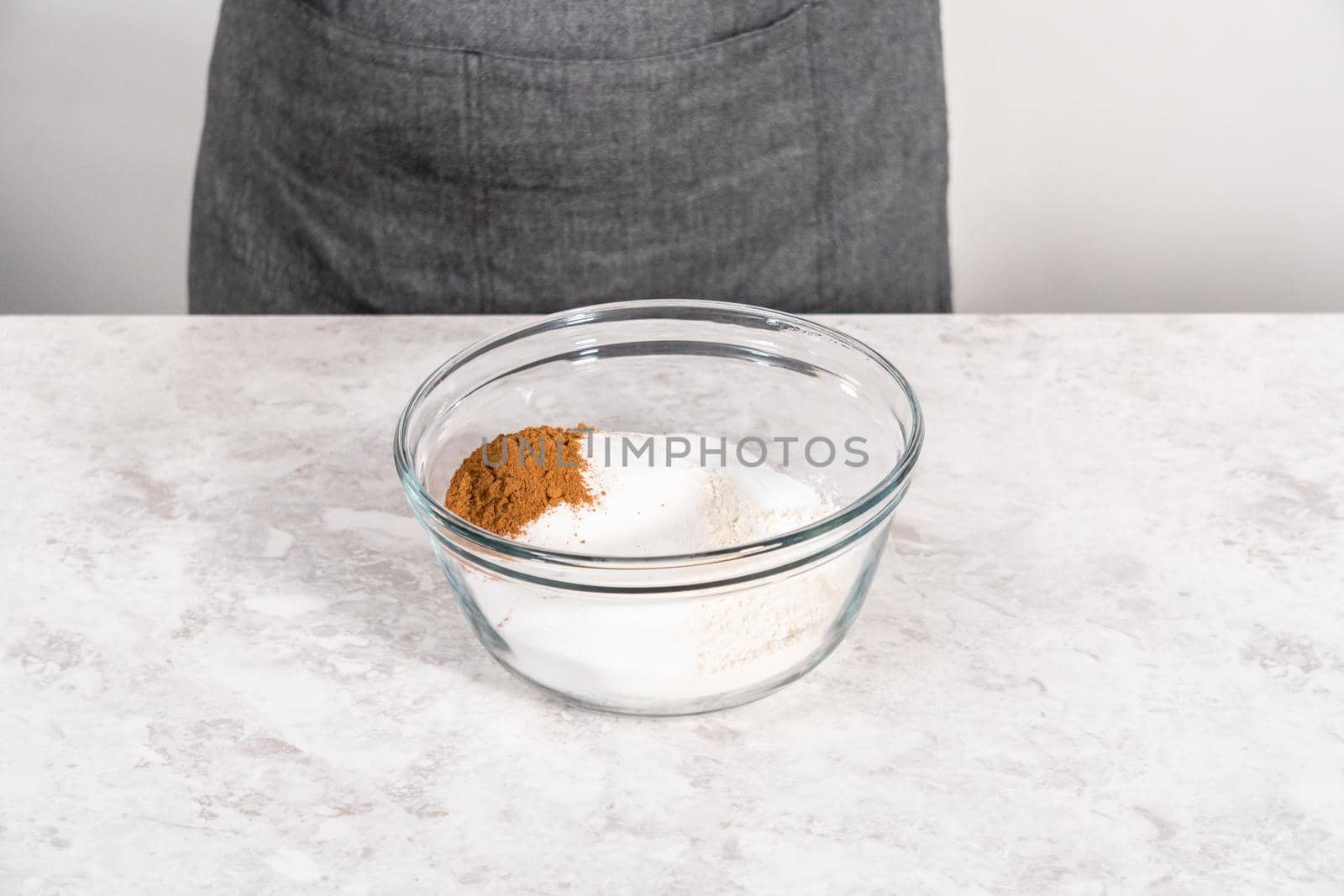 Mixing ingredients in a glass mixing bowl to bake sweet pumpkin bread.