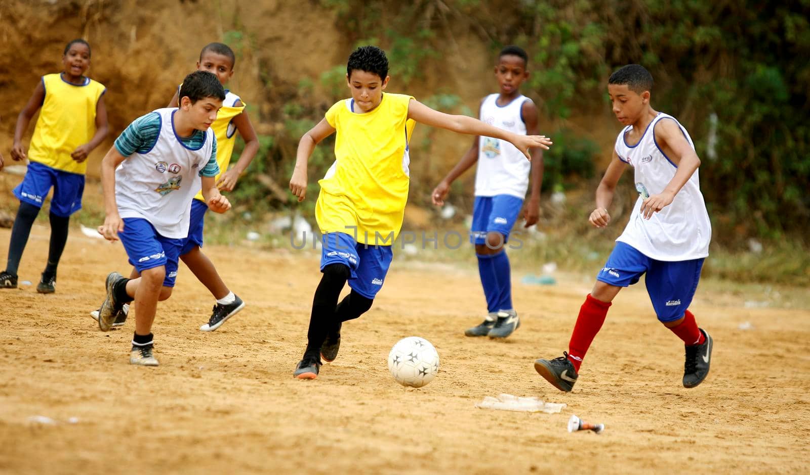 salvador, bahia / brazil - december 21, 2015: young people are seen playing sports on the ground football field in the Fazenda Grande neighborhood in the city of Salvador.