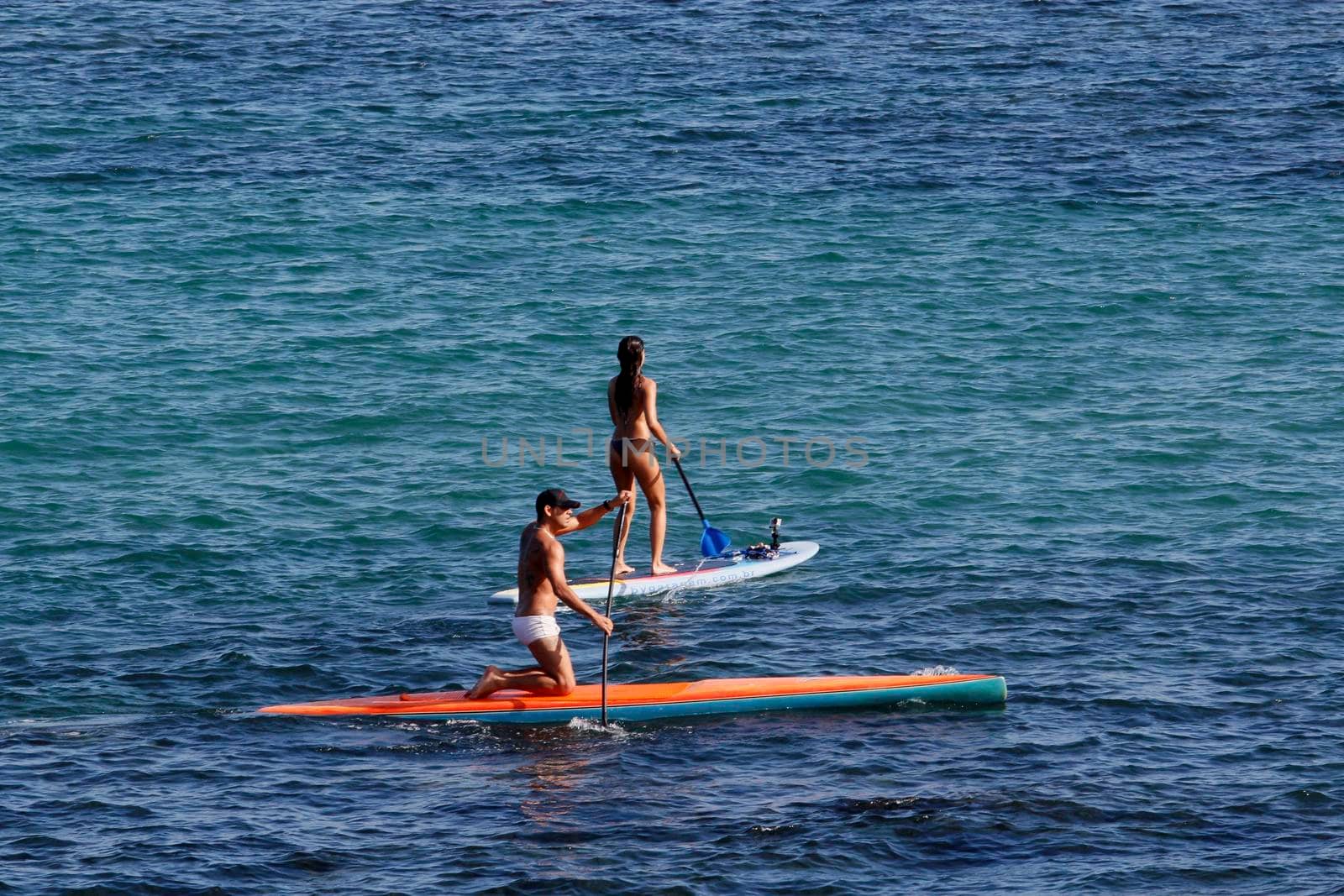 salvador, bahia / brazil - august 31, 2014: People are seen practicing stand up pedal on the beach of Porto da Barra, during the summer of the city of Salvador.