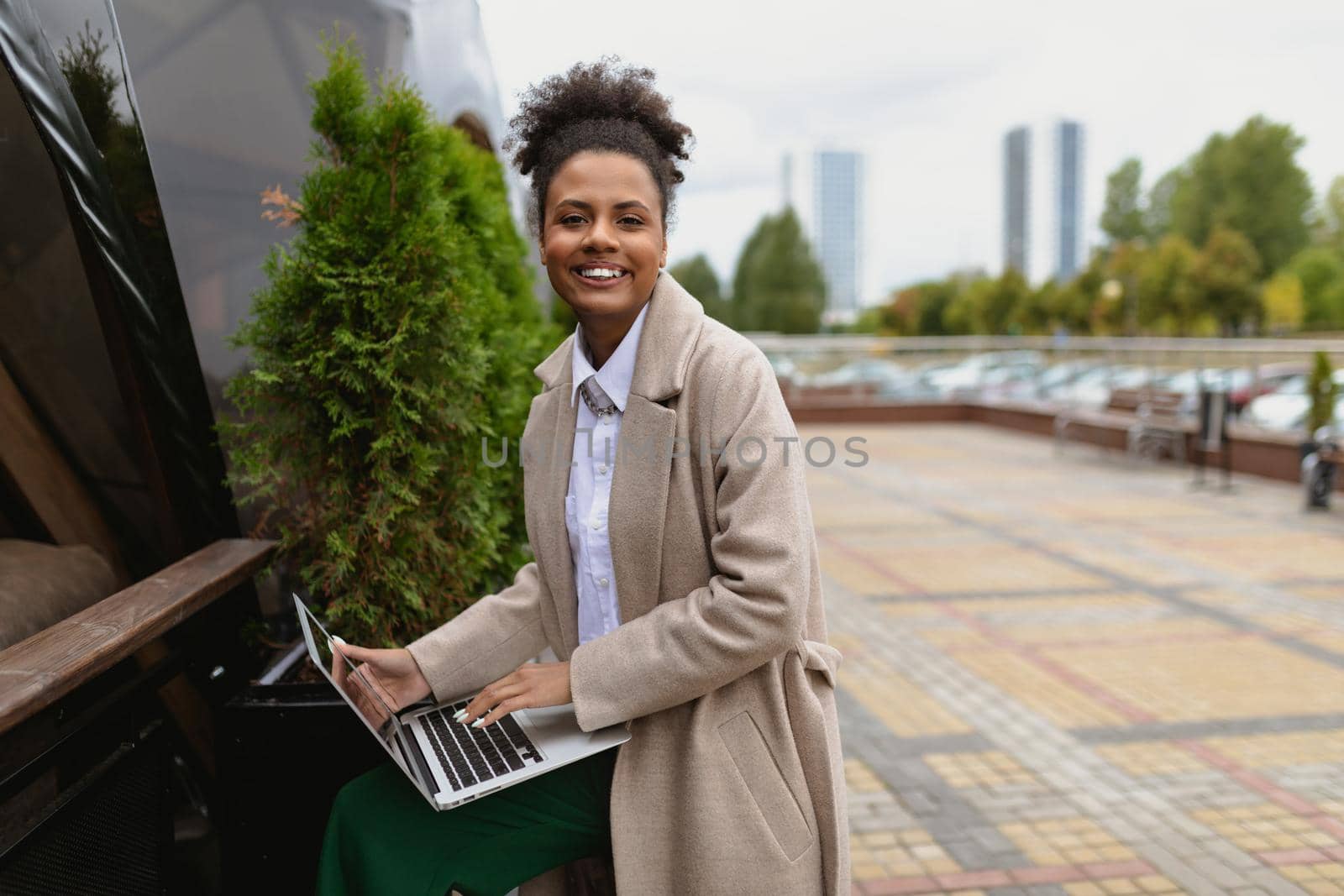 young african american woman working online on laptop outdoors in the city.