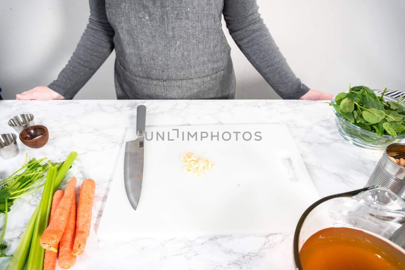 Cutting organic garlic on a white cutting board.