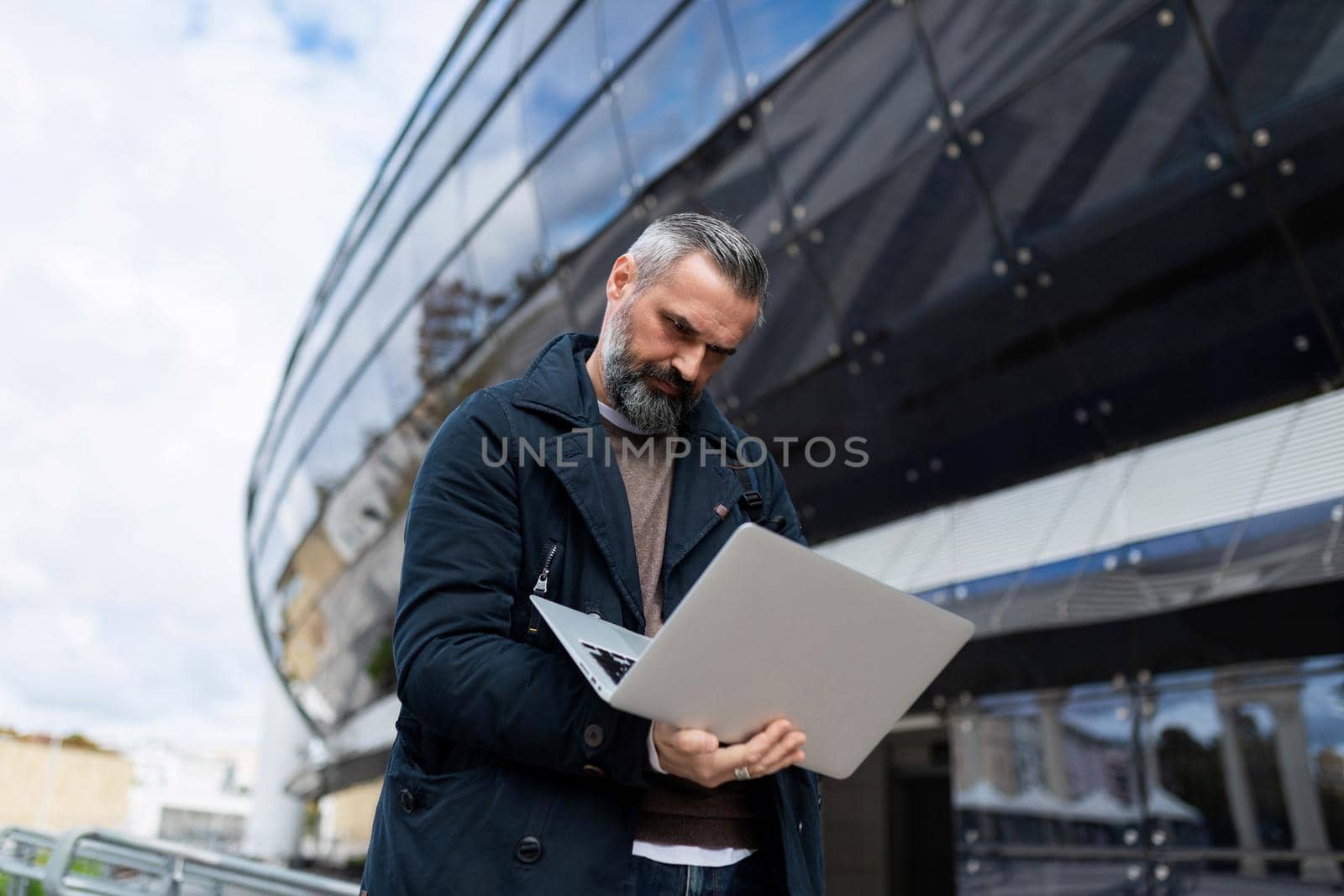 male entrepreneur working online on a laptop before boarding a plane at the airport.