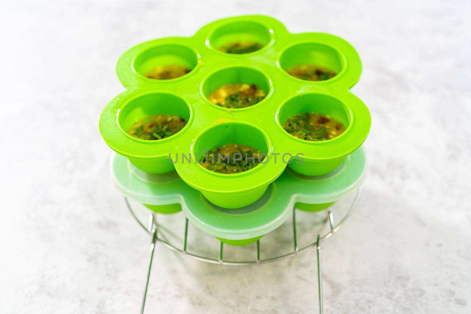 Filling silicone molds with egg mixture to make egg bites in a pressure cooker.
