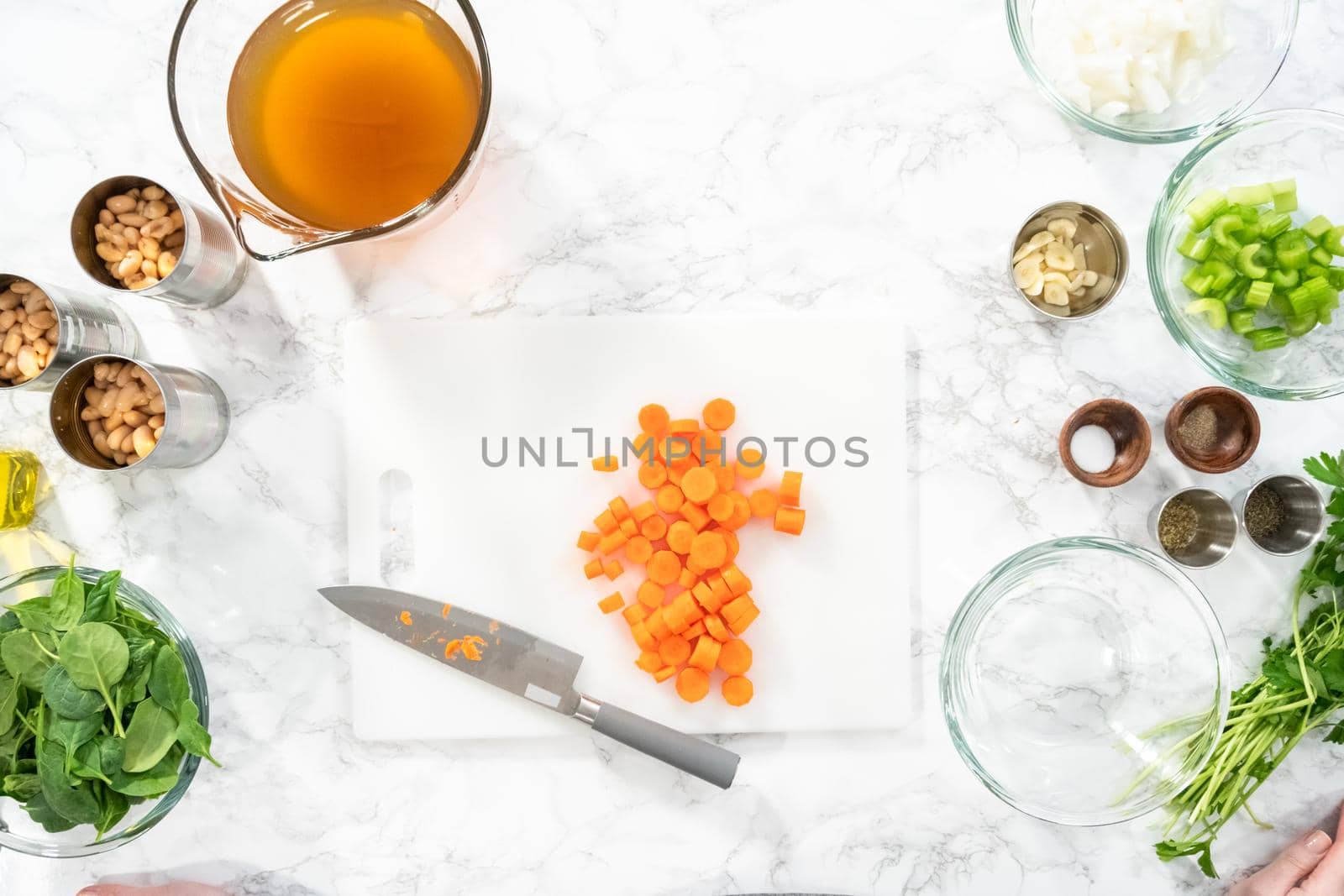 Flat lay. Cutting organic carrots on a white cutting board.